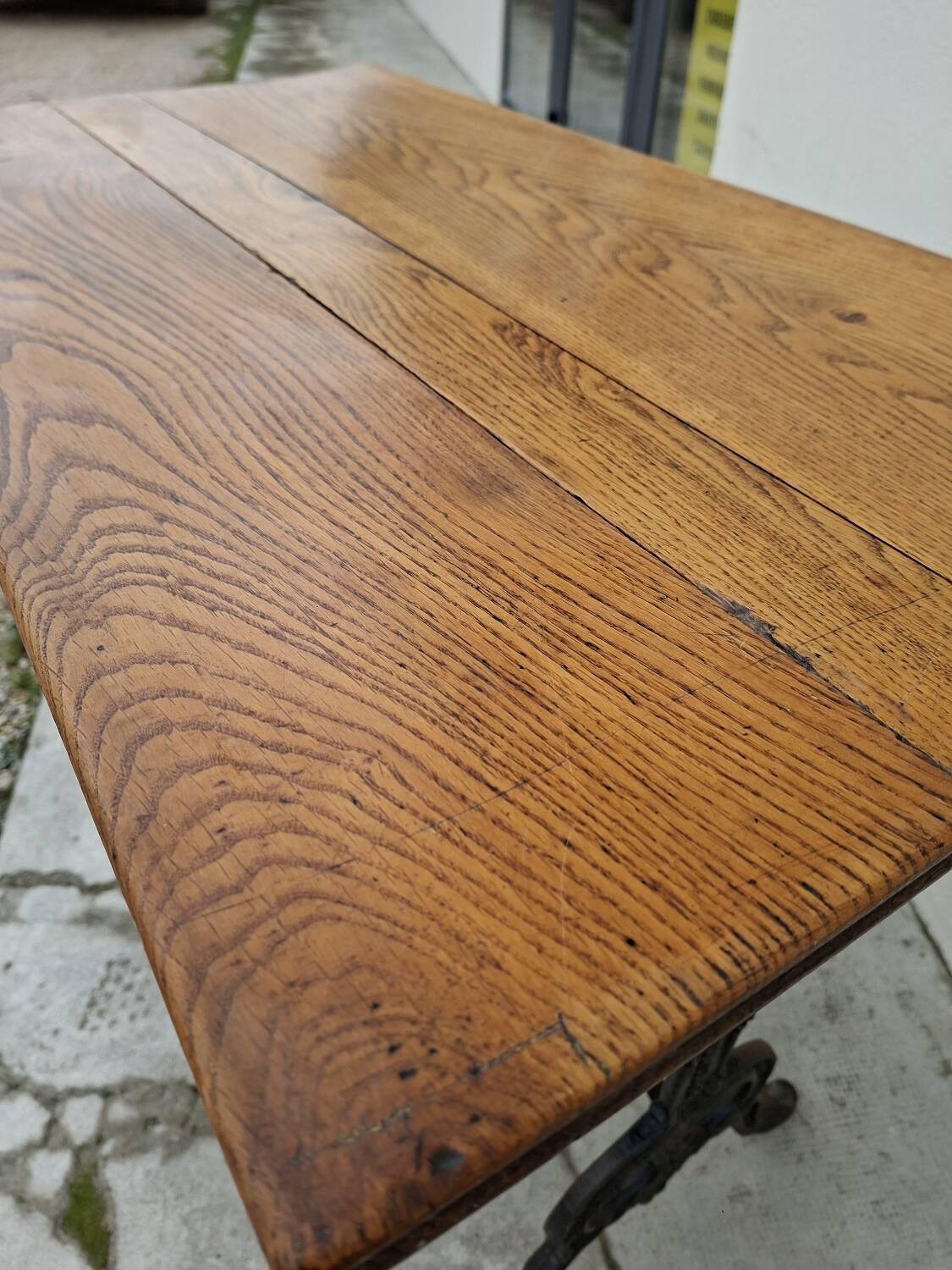 Solid oak bistro table with a cast iron base, signed.