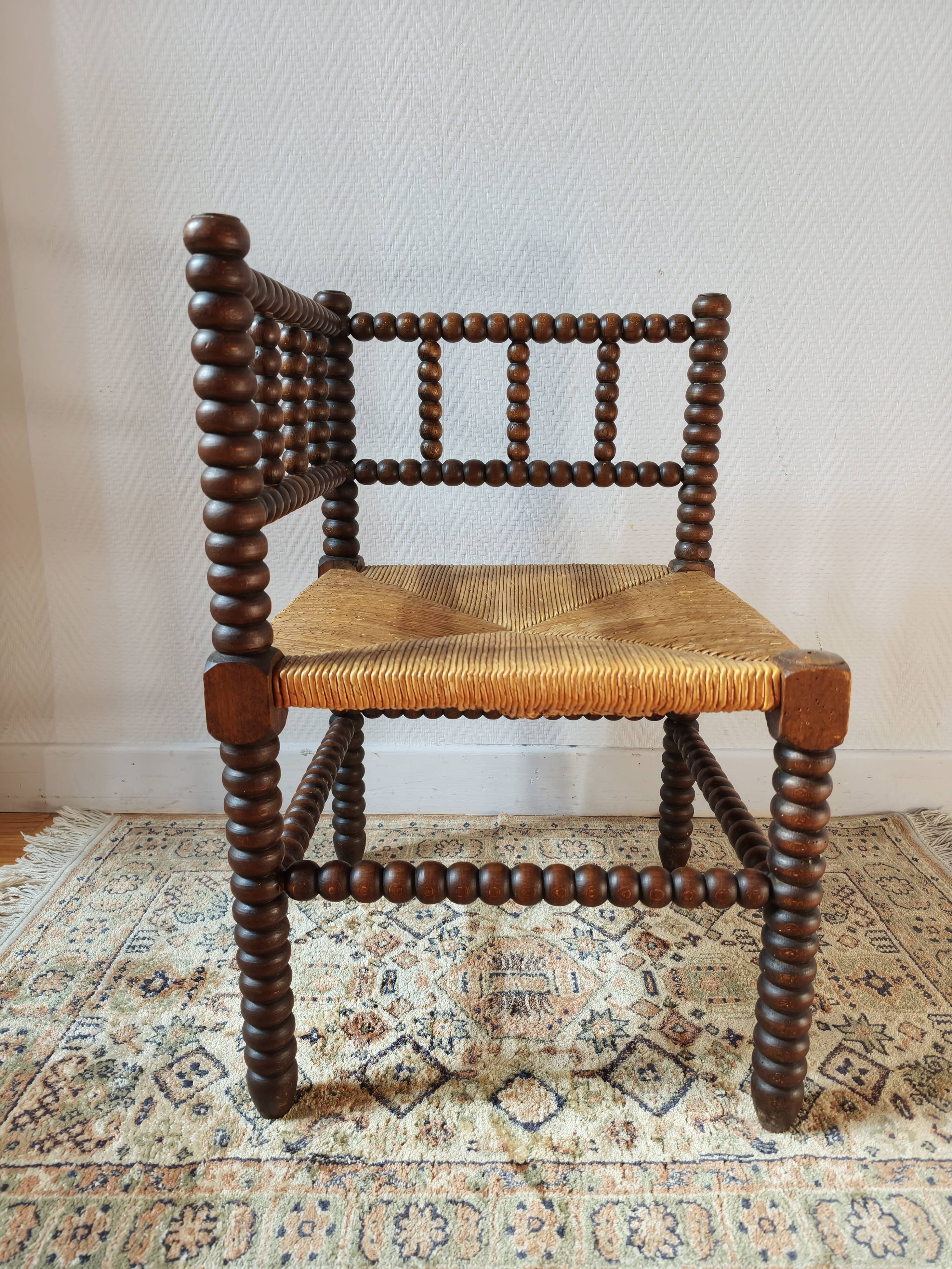Old wooden turned spindle fireside chair with a straw seat.