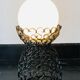 Handcrafted wrought iron lamp with a white opaline globe.