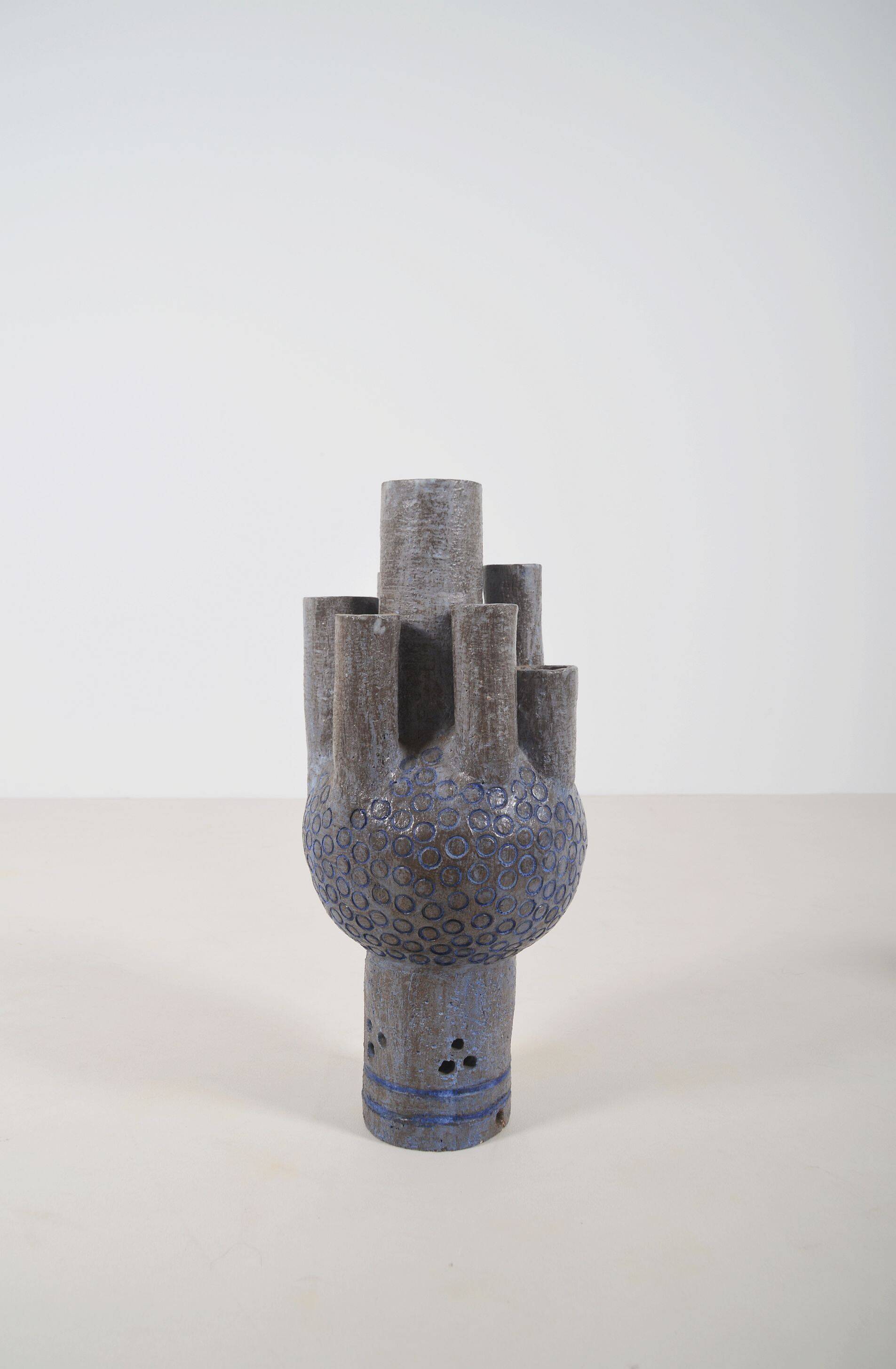 Sculpture en céramique avec des motifs circulaires et une signature.