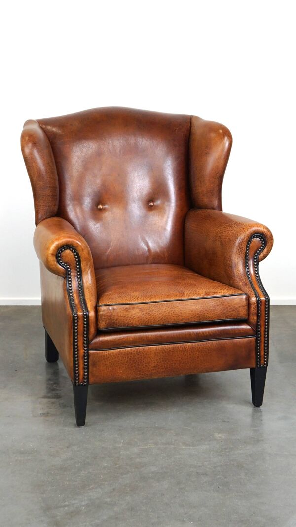 Fauteuil à oreilles en cuir de mouton, avec clous et passepoil noir
