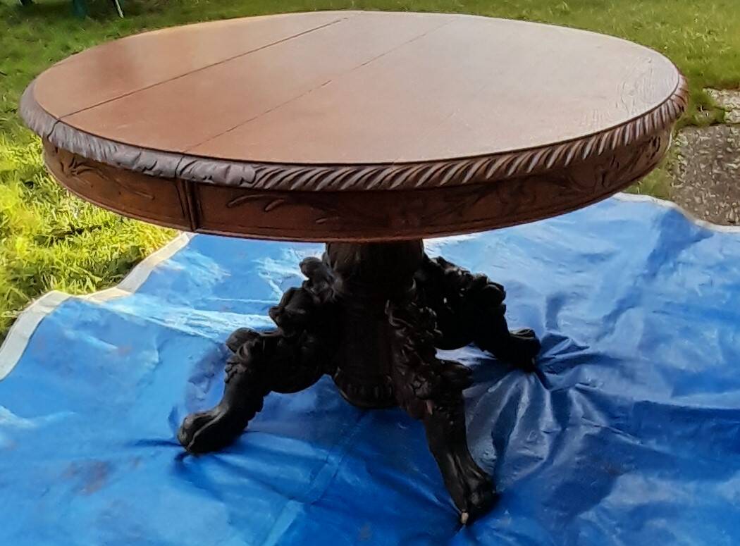 Round table in molded and carved oak with quill decoration, central shaft with 4 runners