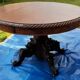Round table in molded and carved oak with quill decoration, central shaft with 4 runners