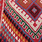 Red carpet with multicolored Berber patterns woven with hands