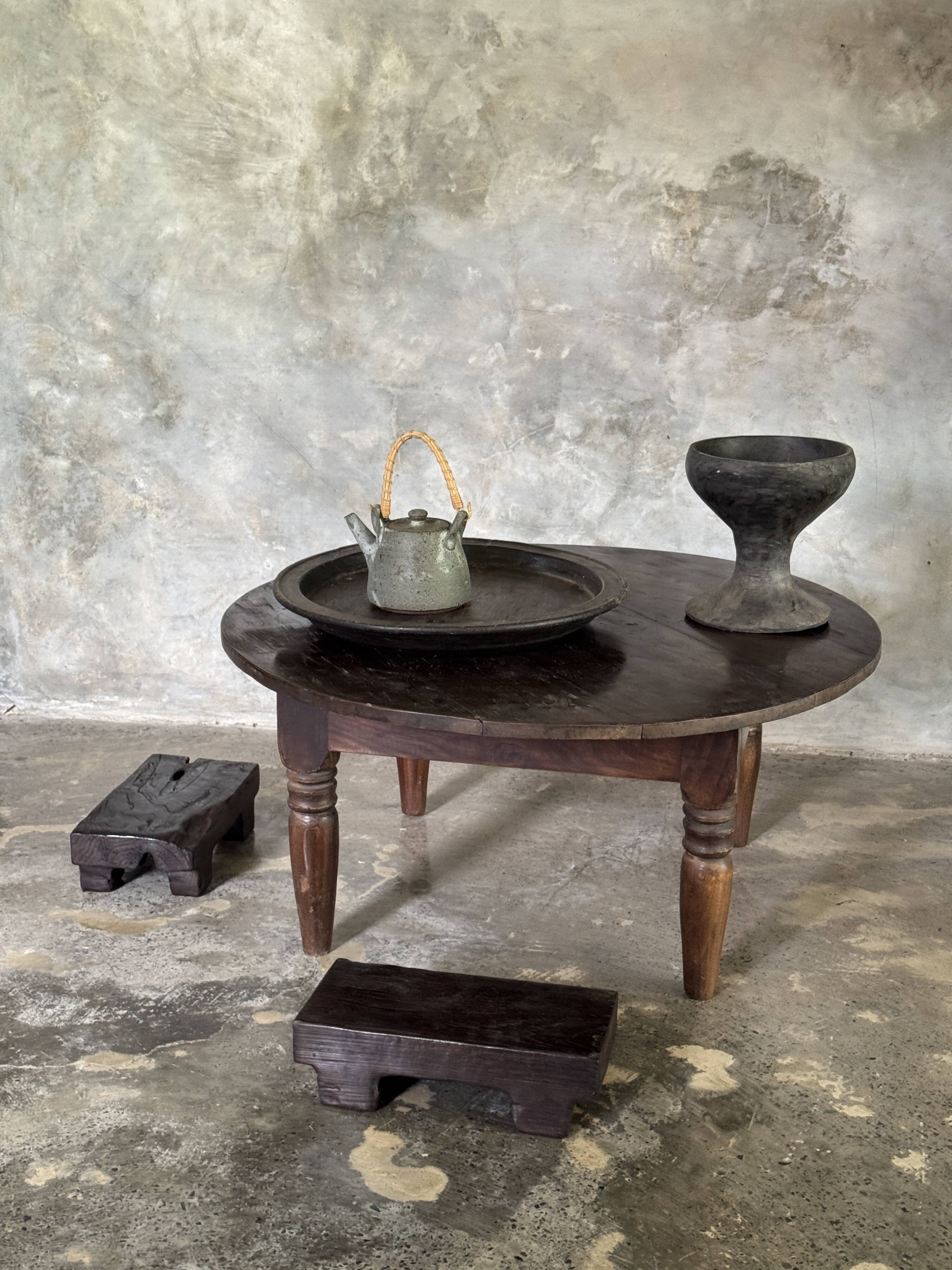 Coffee table, round antique Indonesian teak table with straight legs.