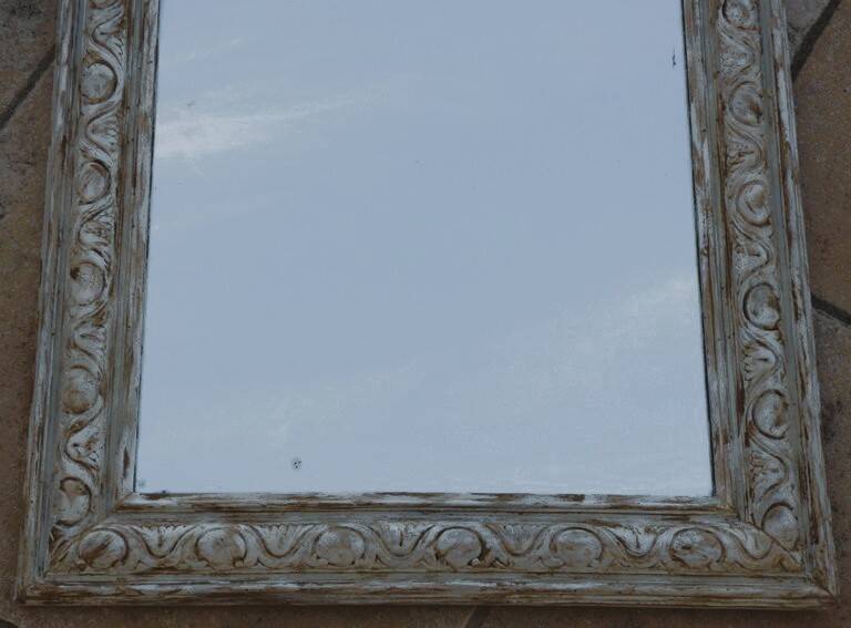 Chic and stylish antique mirror with carved wooden frame in whitewashed