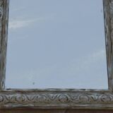 Chic and stylish antique mirror with carved wooden frame in whitewashed