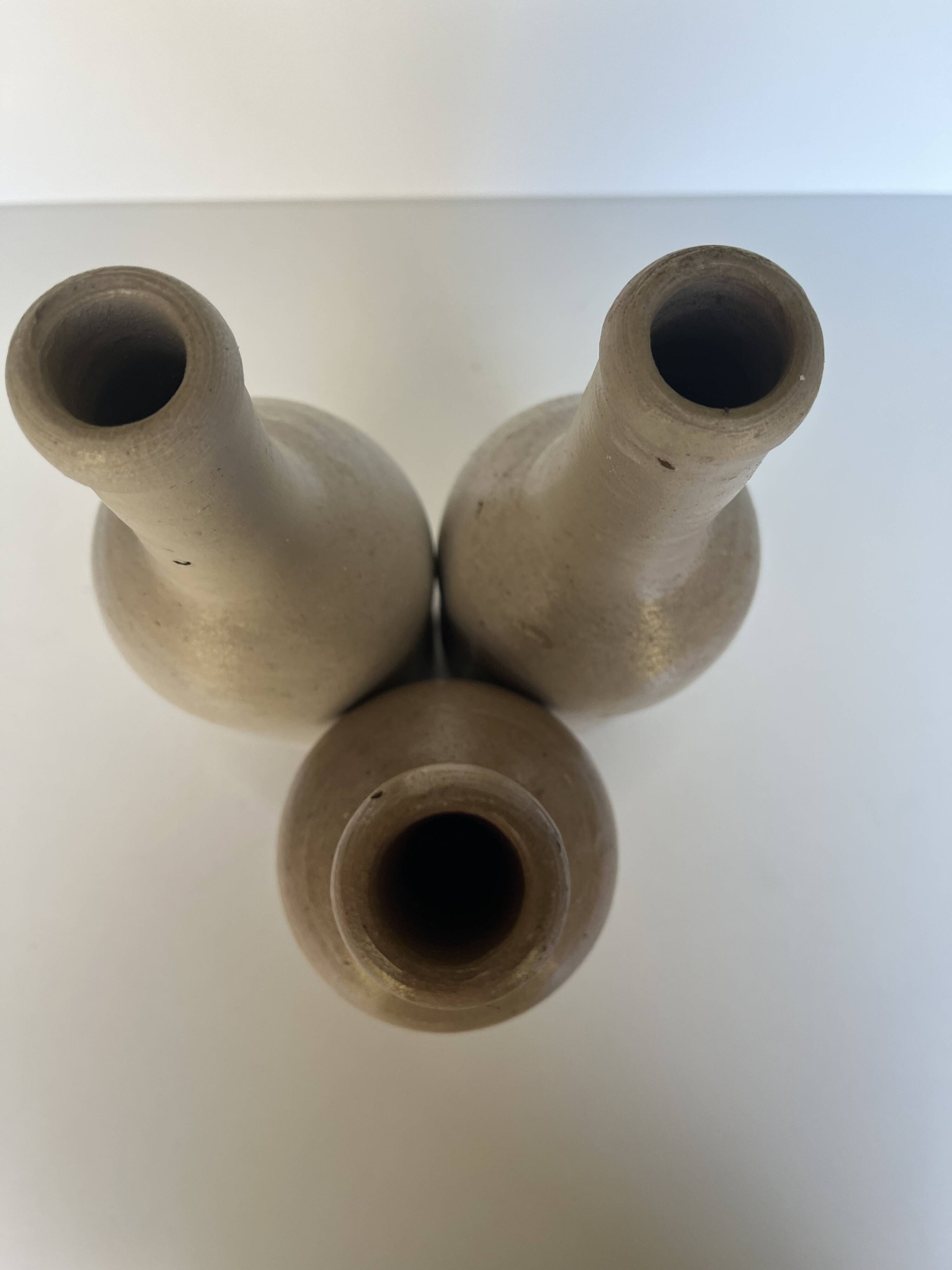 Trio of antique matte stoneware bottles