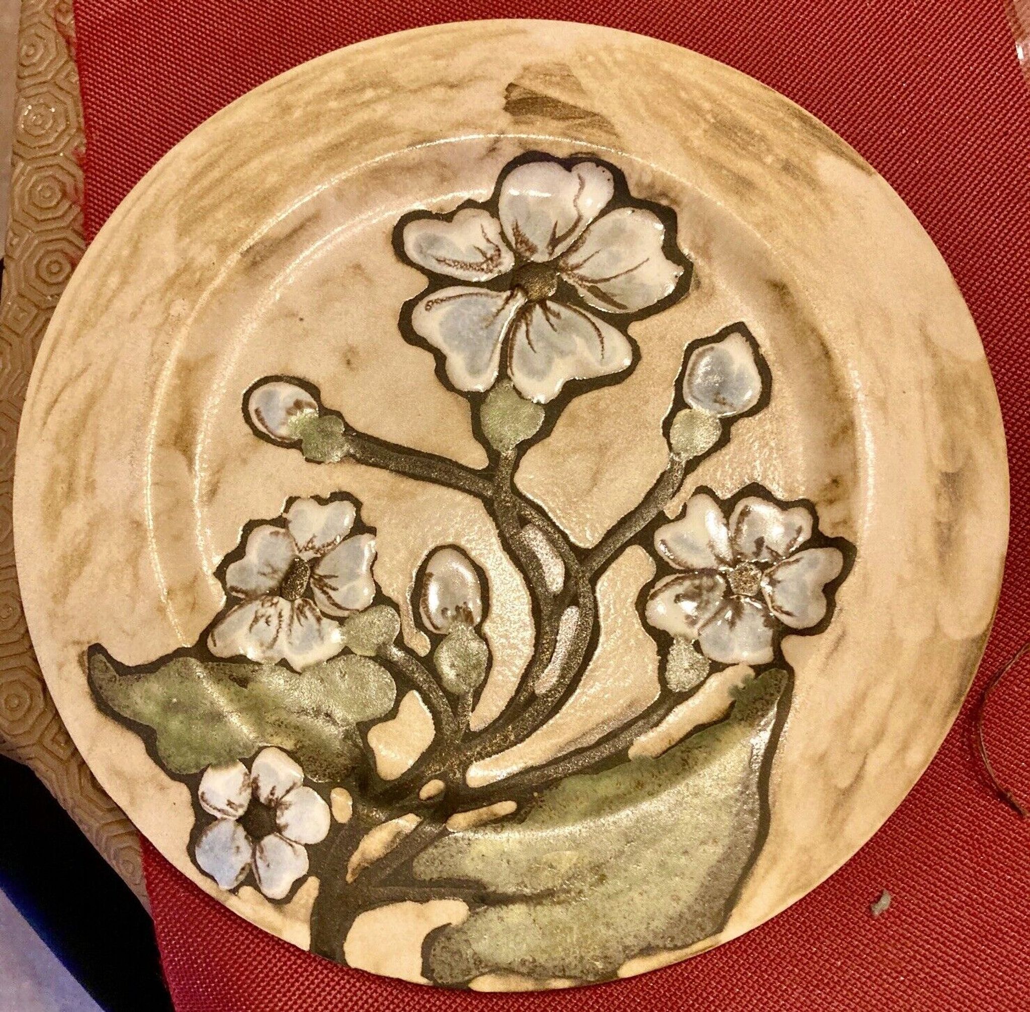 Assiette en céramique, décor de fleur, monogramme a identifier au verso