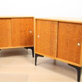 A pair of vintage mid-century bedside tables with oak sliding doors