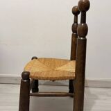 Low fireplace chair in the style of Charles Dudouyt – wood and straw seat.
