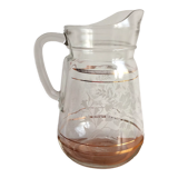 Old glass water pitcher with white flowers in relief with gold edging