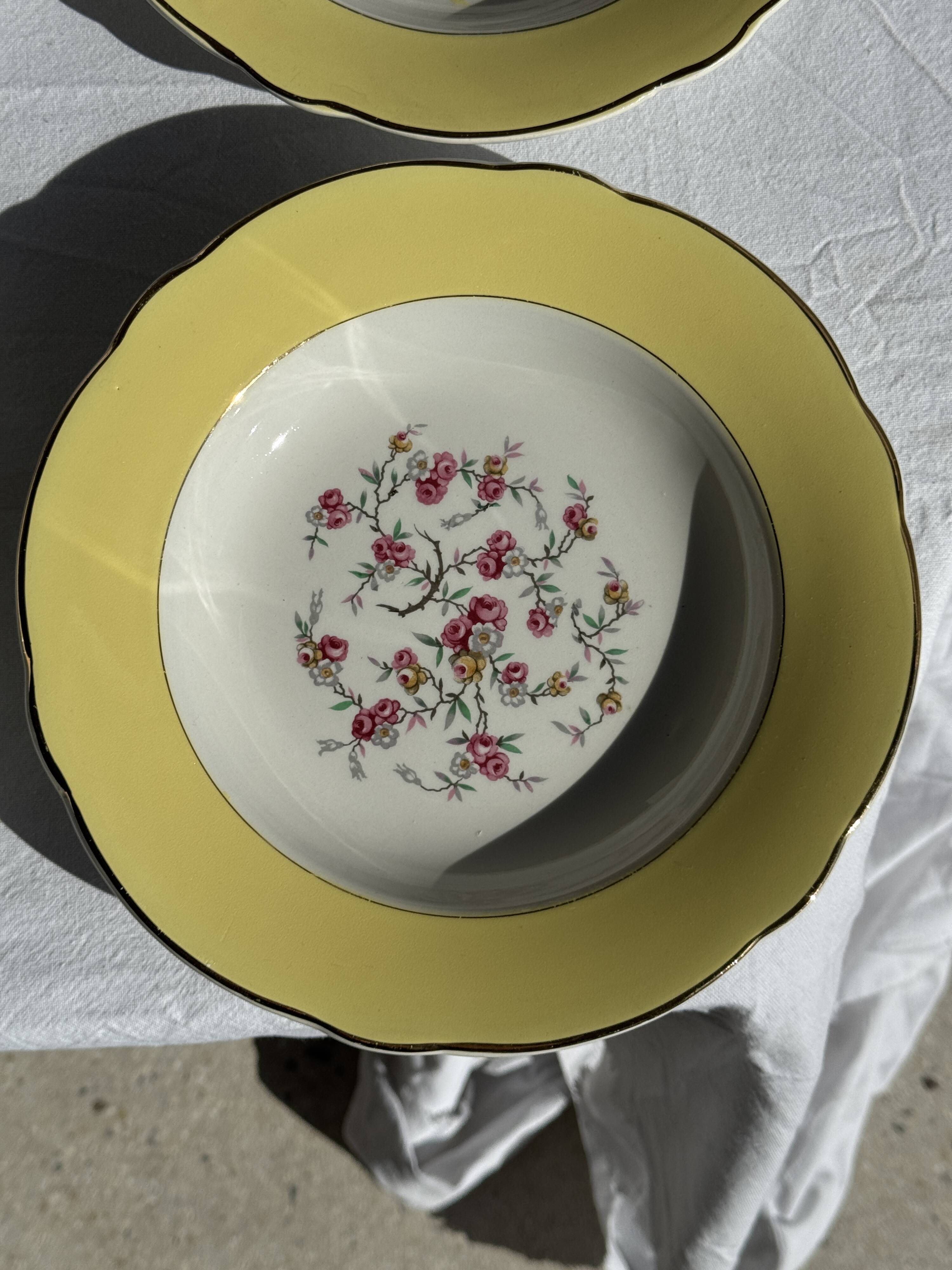 Set of 9 large vintage yellow deep plates with pink flowers and a gold rim.