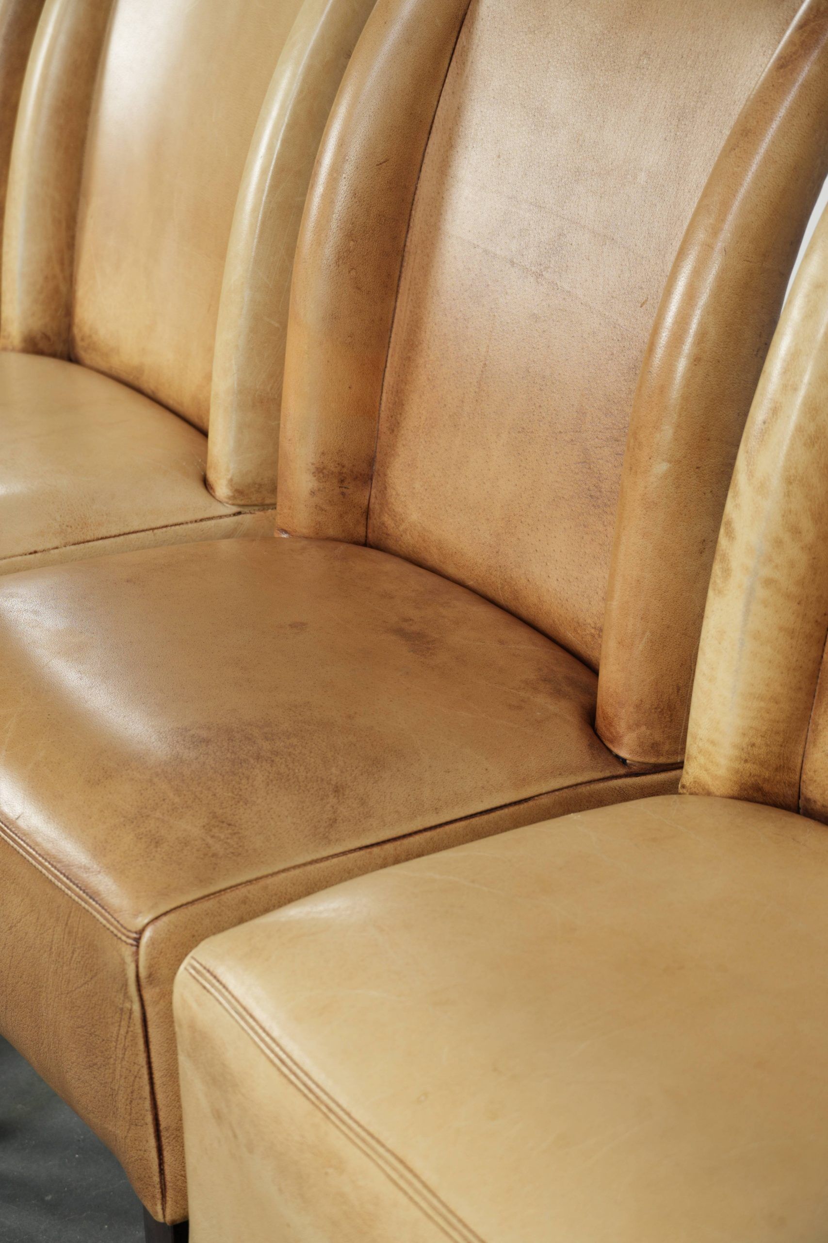Ensemble de quatre chaises de salle à manger en cuir de vache avec un siège confortable et un dossier haut.
