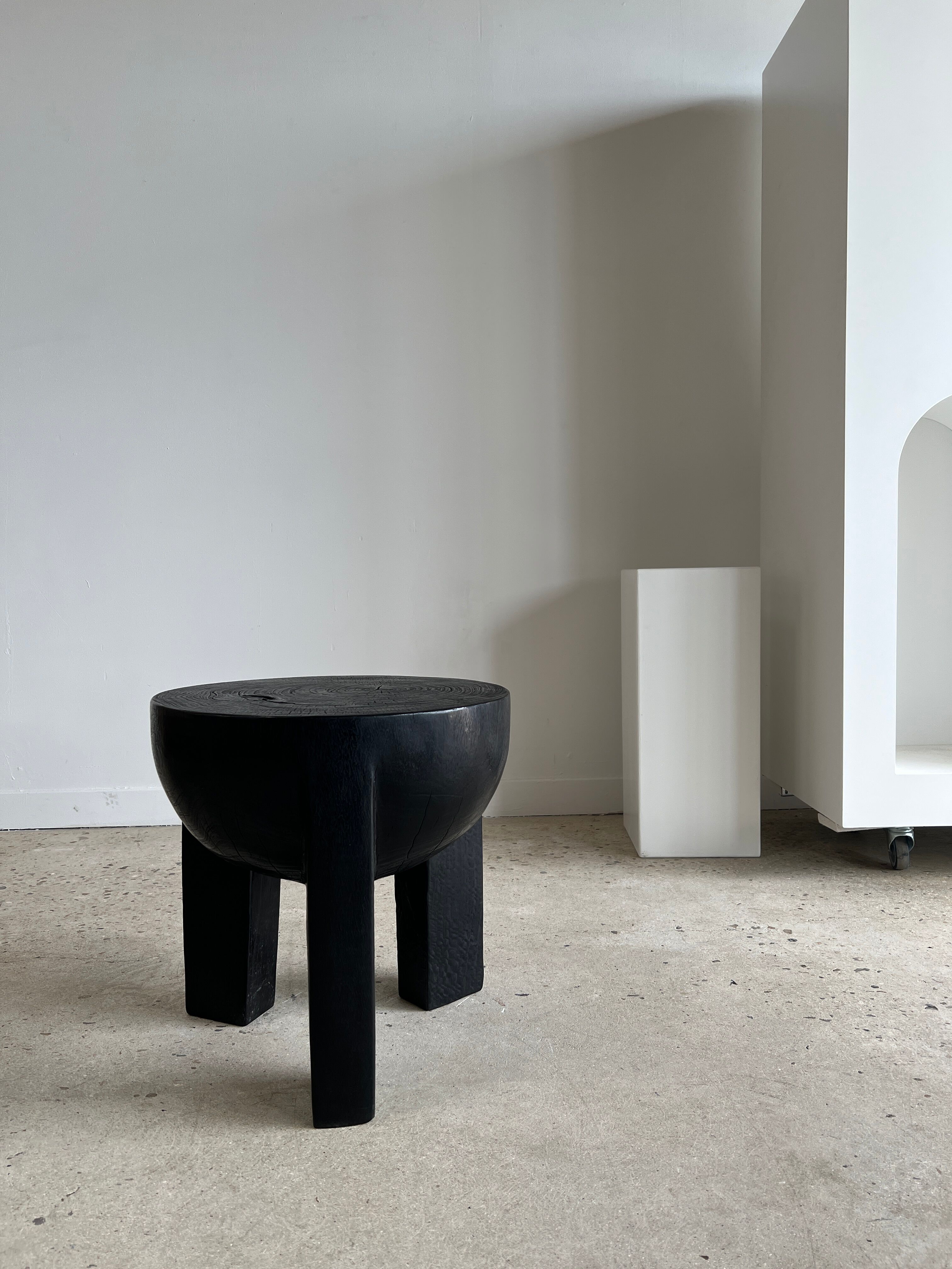 Black mango wood tripod side table with a semi-spherical top, height: 45 cm, diameter: 44 cm.