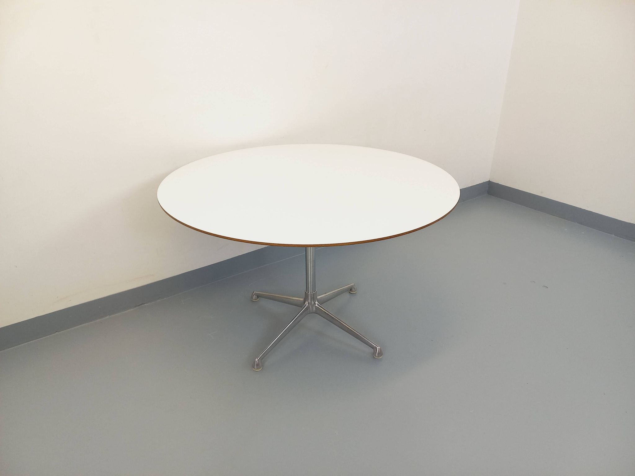 Vintage Eames round table for Vitra in white melamine, wood, and metal.