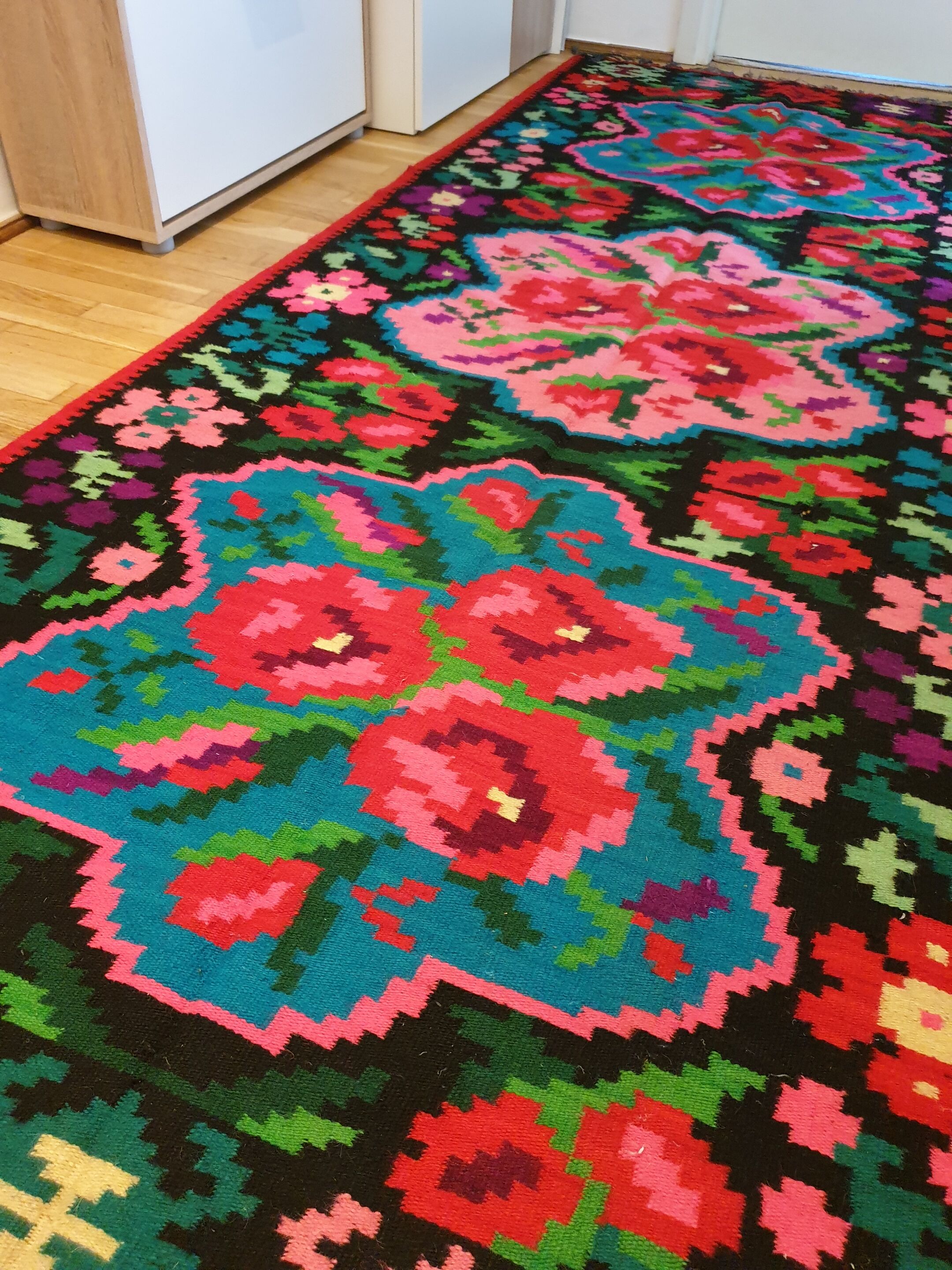 Colorful kilim on black background with floral design