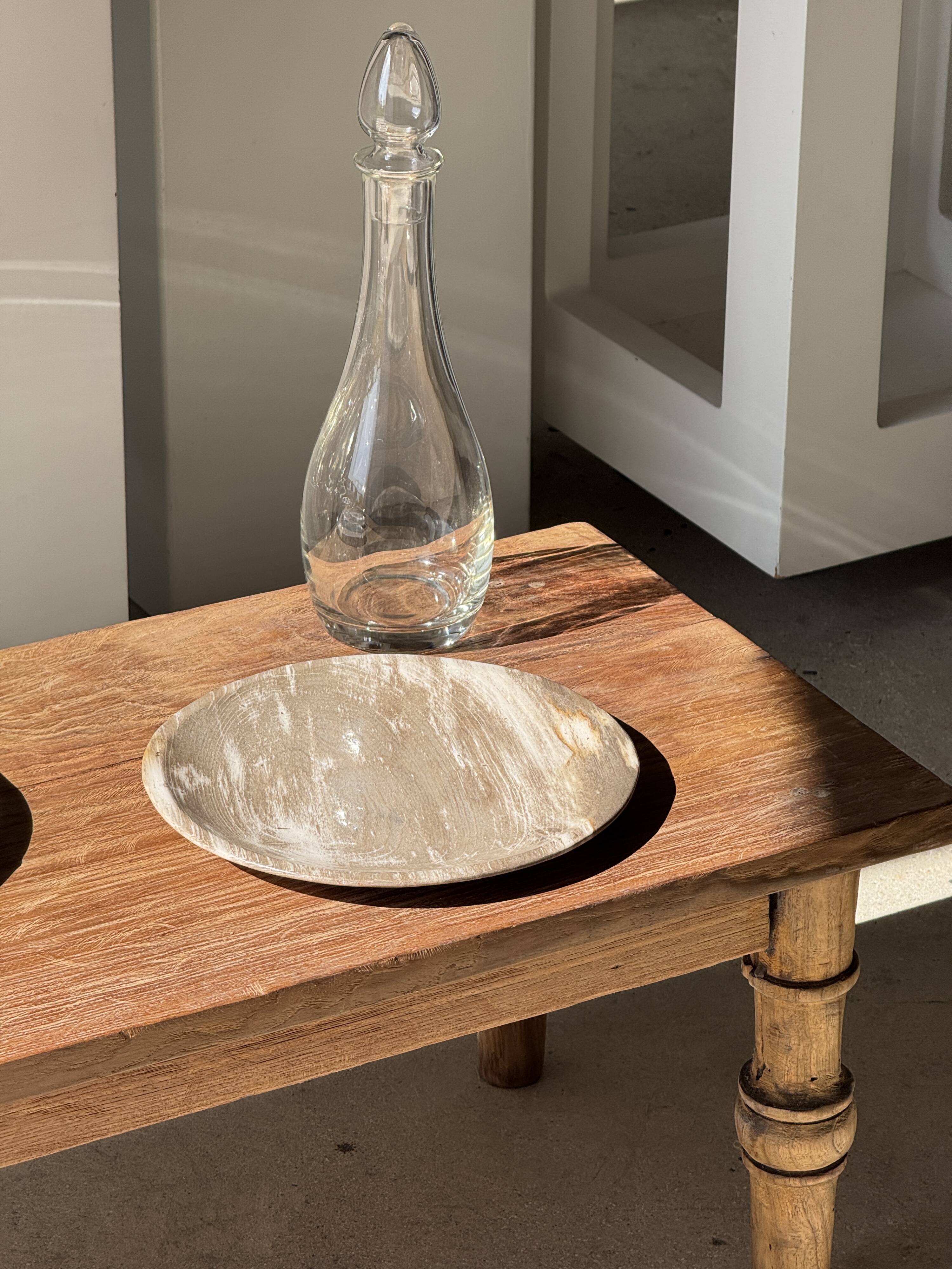 Tray, circular dish or plate made of white striped grey petrified wood.