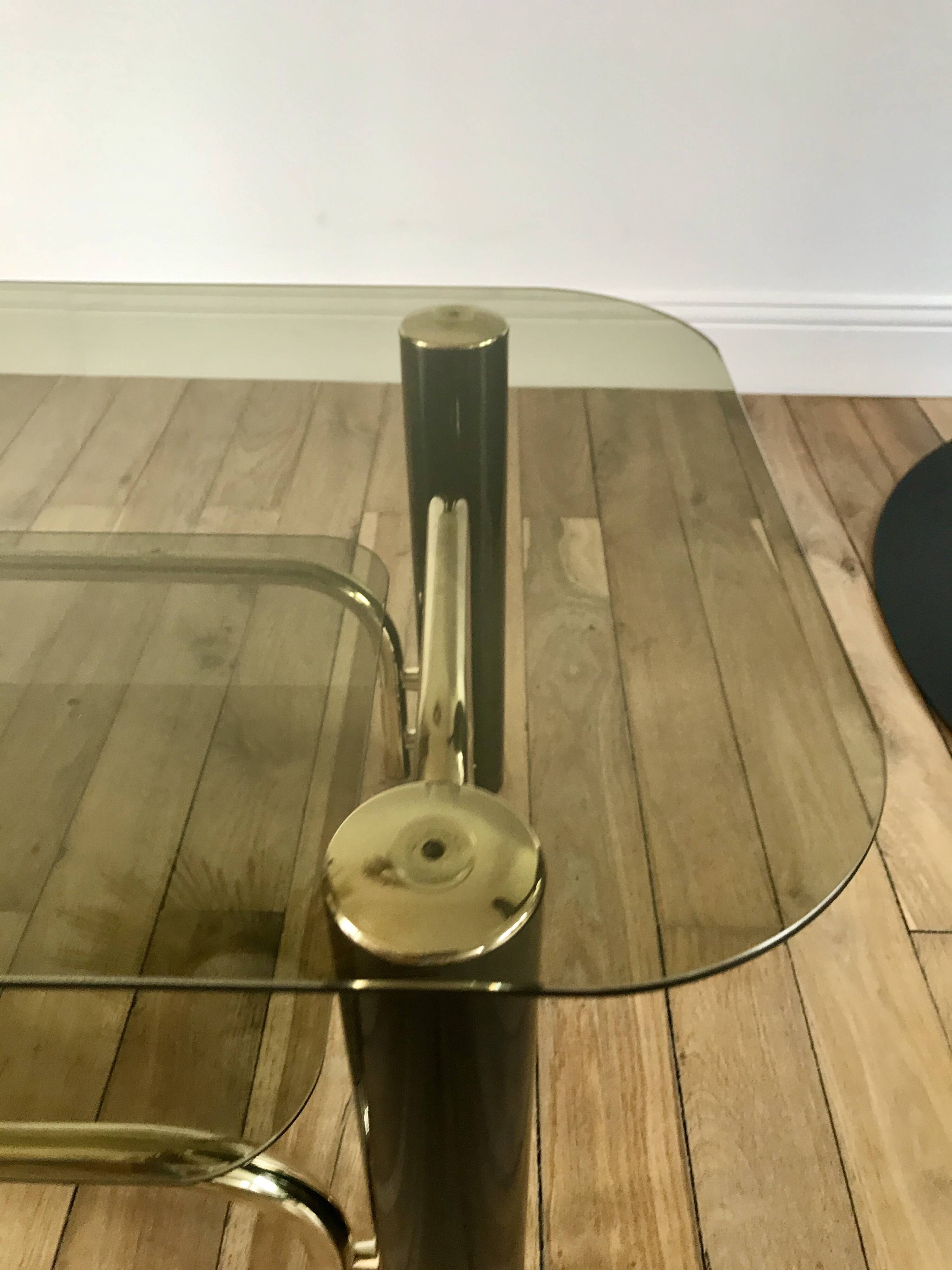 coffee table in smoked glass and black and gold metal from the 70s