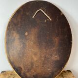 Oval-shaped wooden mirror in gold color
