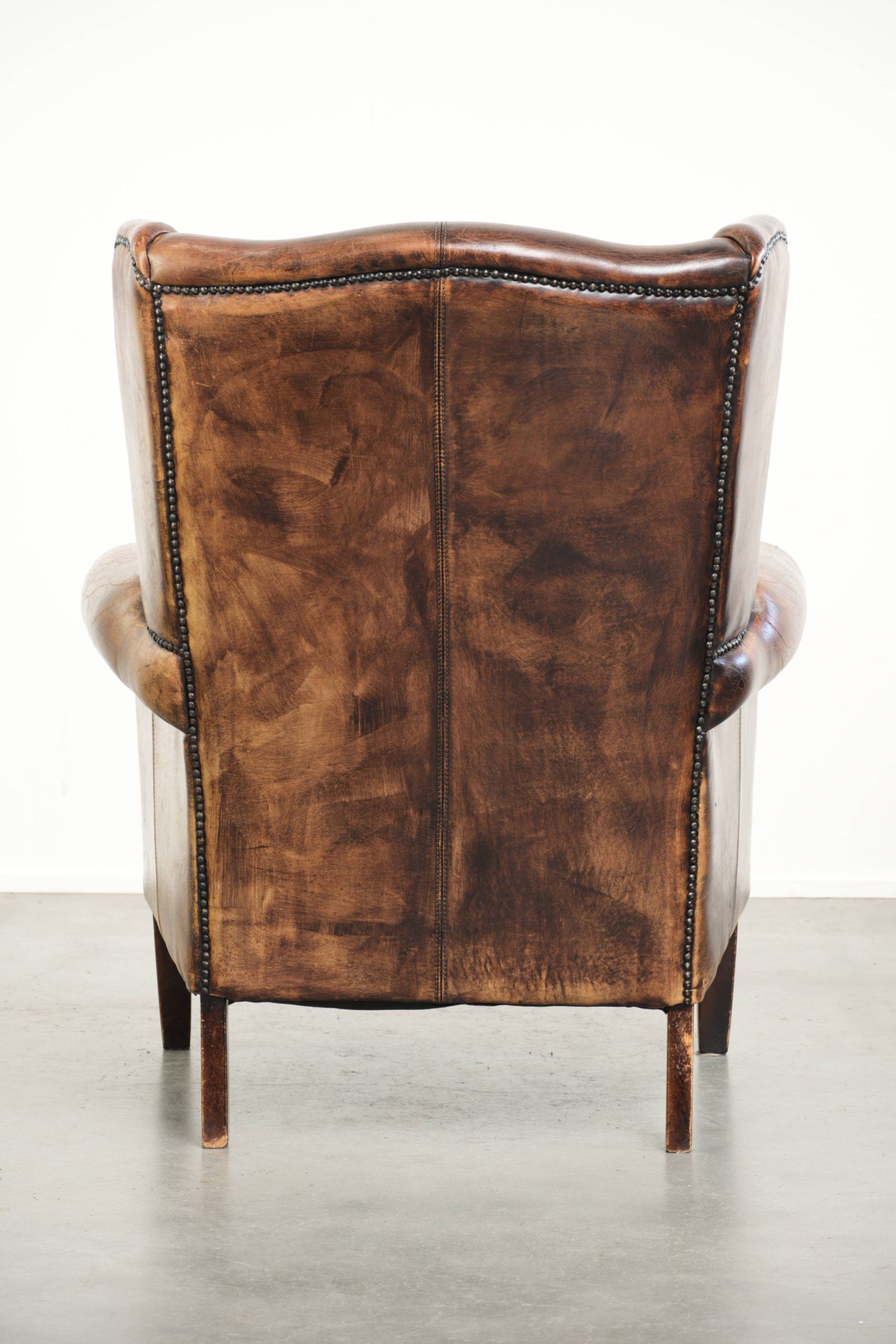 Vintage sheepskin wingback armchair in a deep brown colour finished
