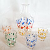 Vintage decanter and its 7 assorted glasses.