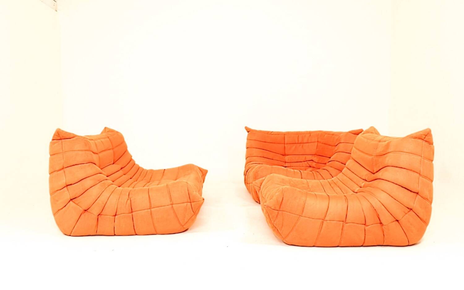 Togo sofa set and armchairs in pumpkin orange, 3 pieces, no label.