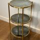 Round bronze side table with triple shelves of églomisé mirrors from Maison Baguès
