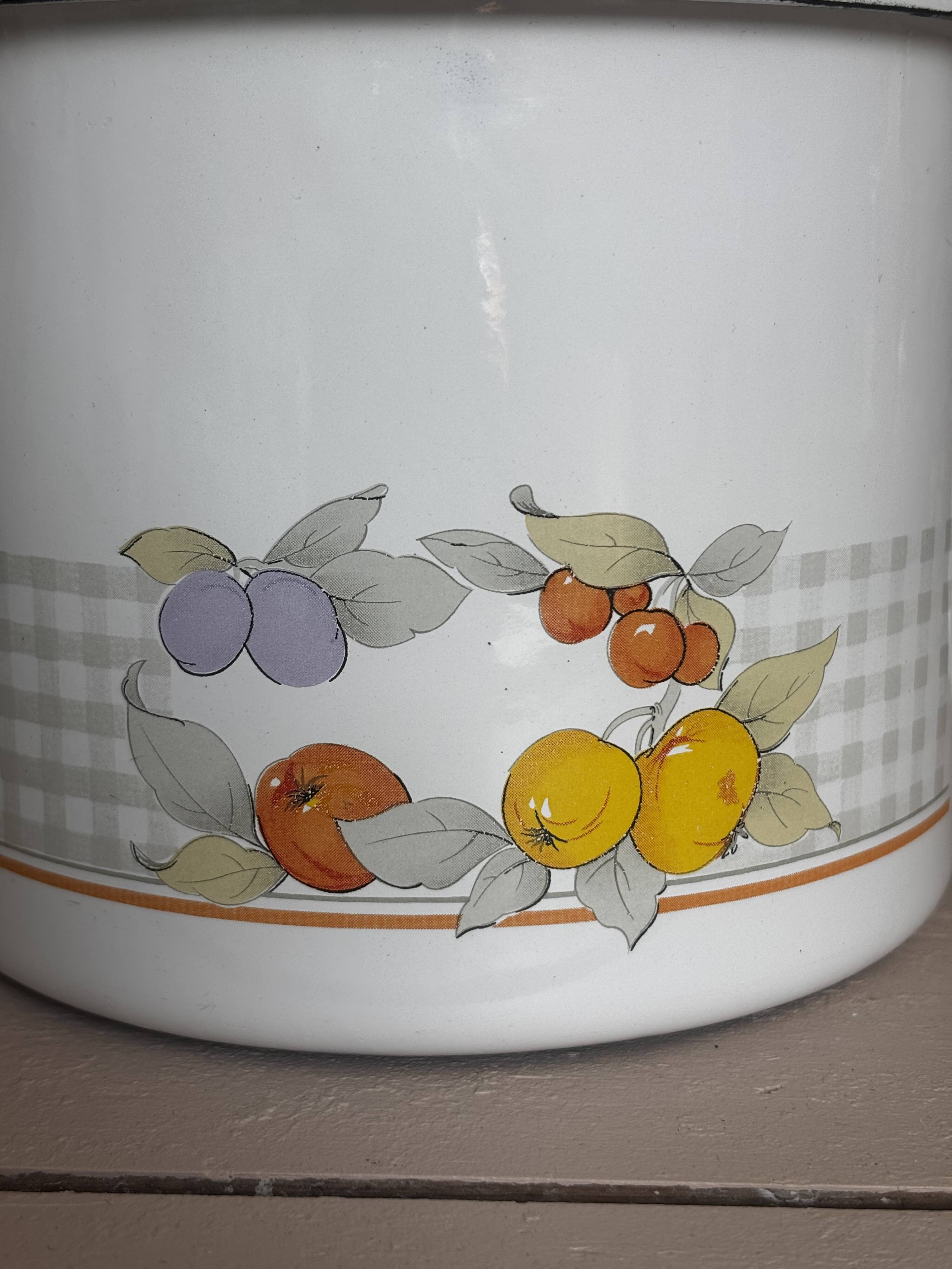 Vintage enamelled white metal milk jug with fruits.