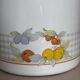Vintage enamelled white metal milk jug with fruits.