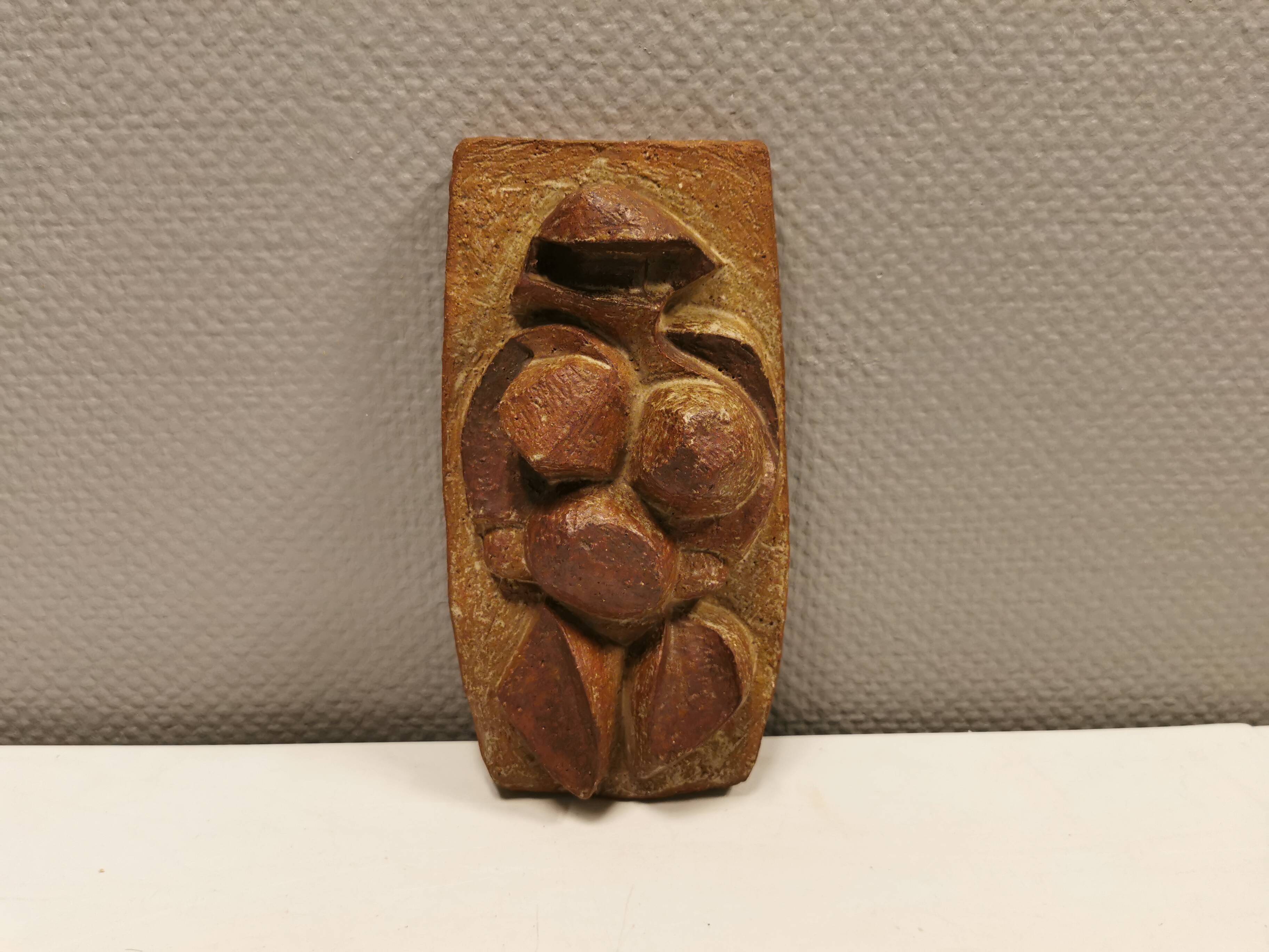 Ceramic relief portraying a lady. Emerging out of the background.