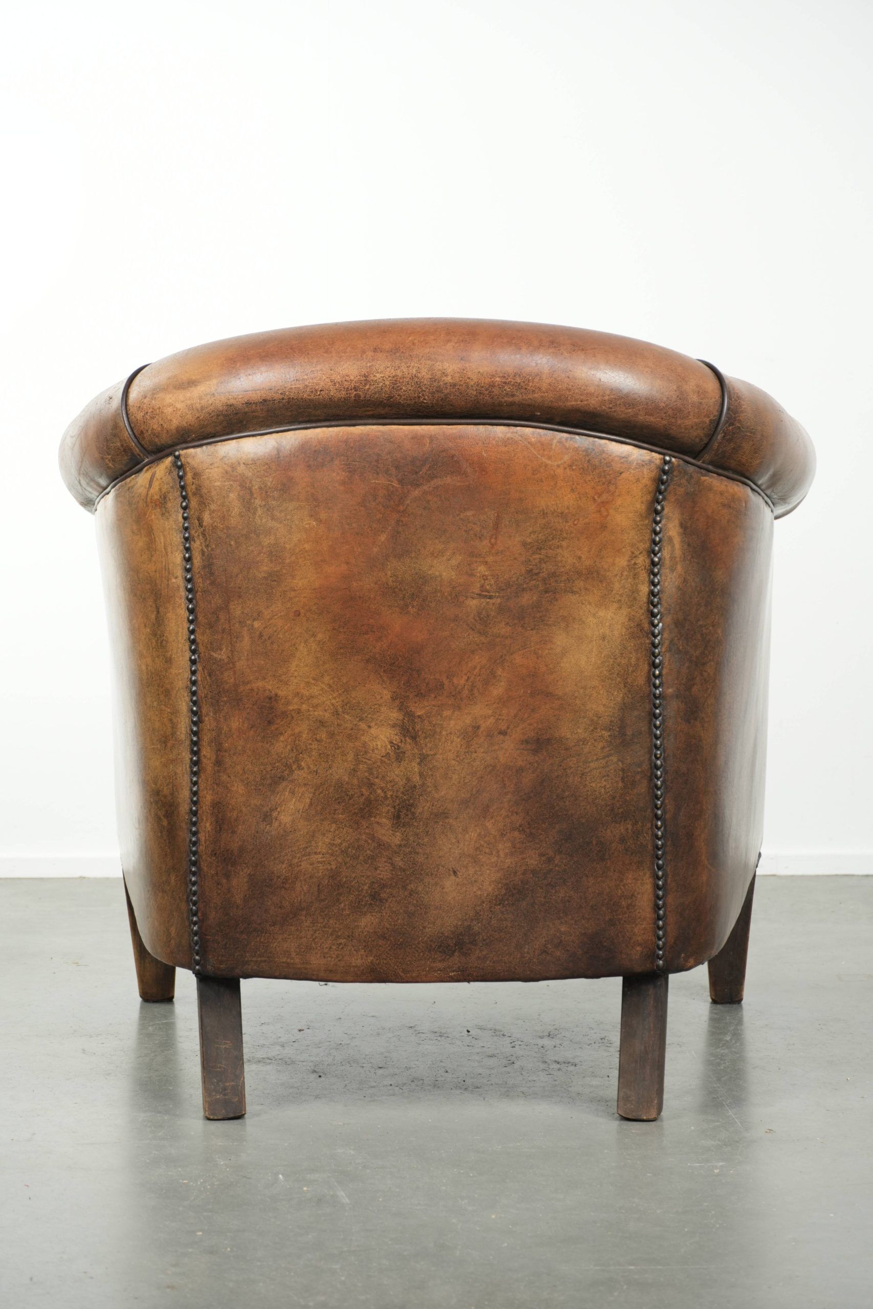 Sheepskin club armchair with beautiful patina and finish with black piping