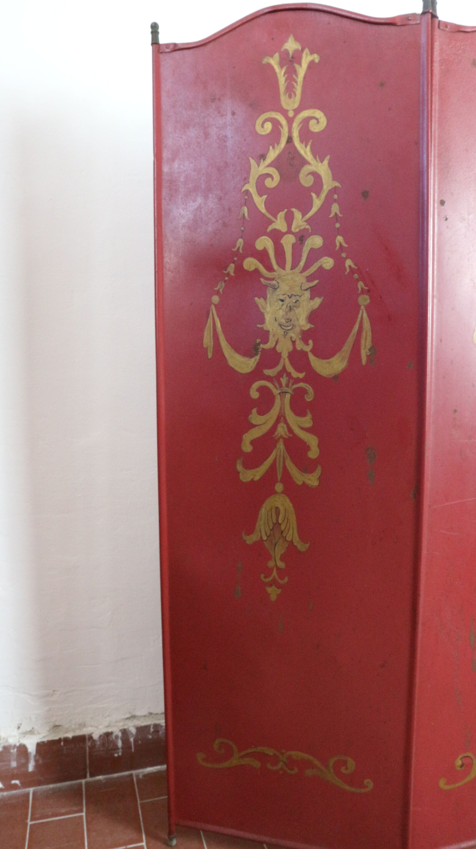 Pare-feu peint en rouge avec des décorations peintes en or