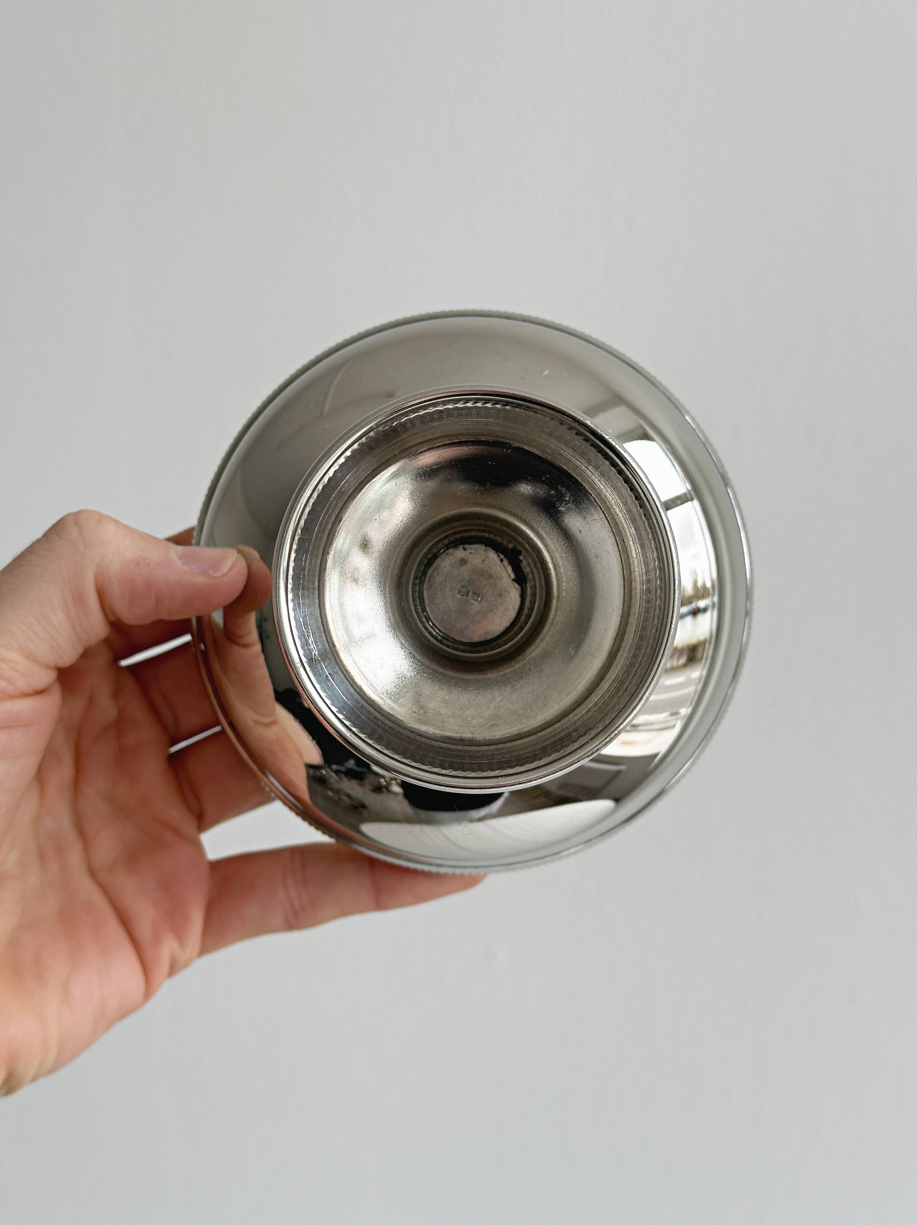 Small silver-plated metal bowl on a stand.