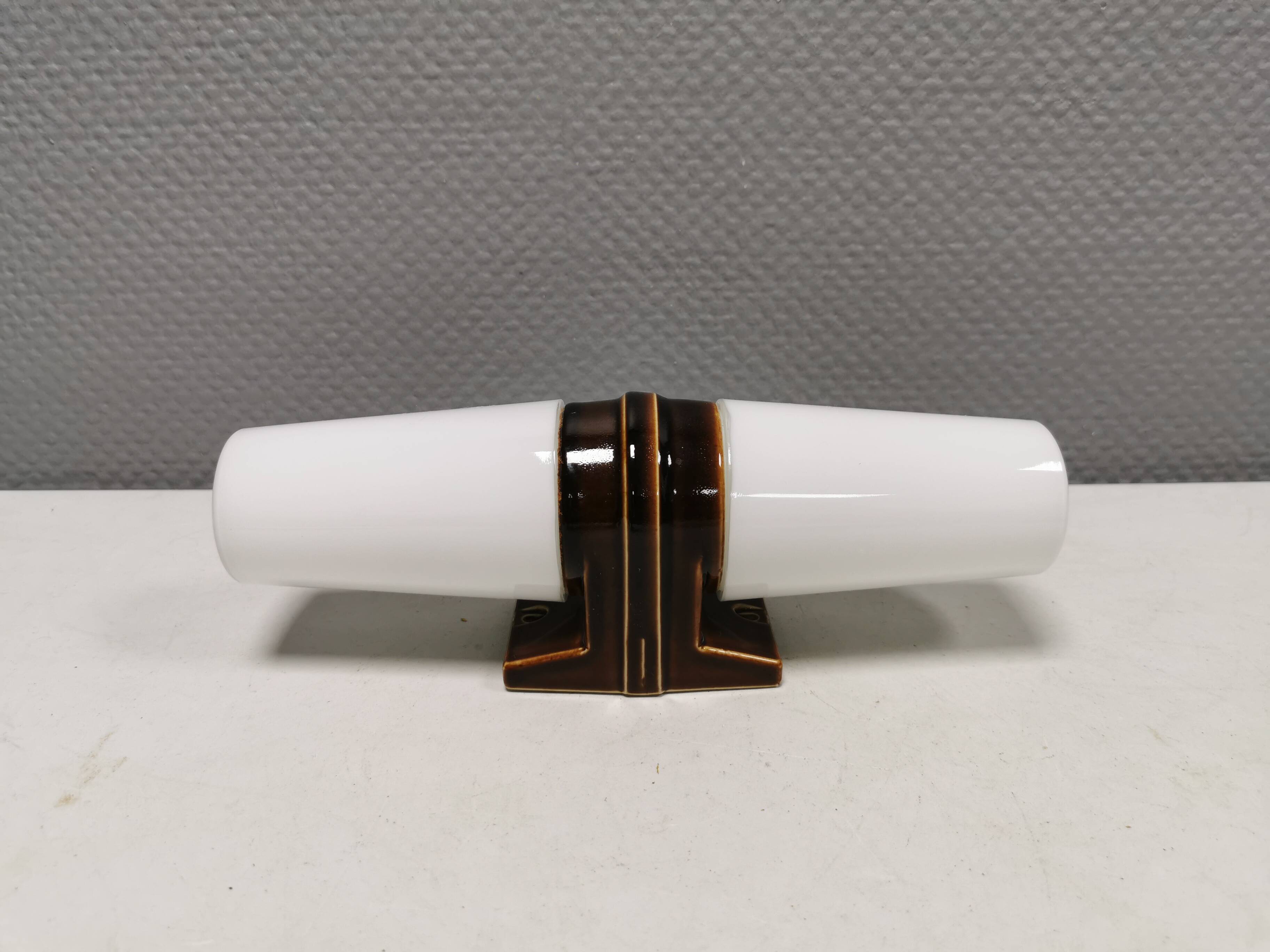 Old bathroom lamp with brown/golden ceramic base, porcelain socket and milky white glass