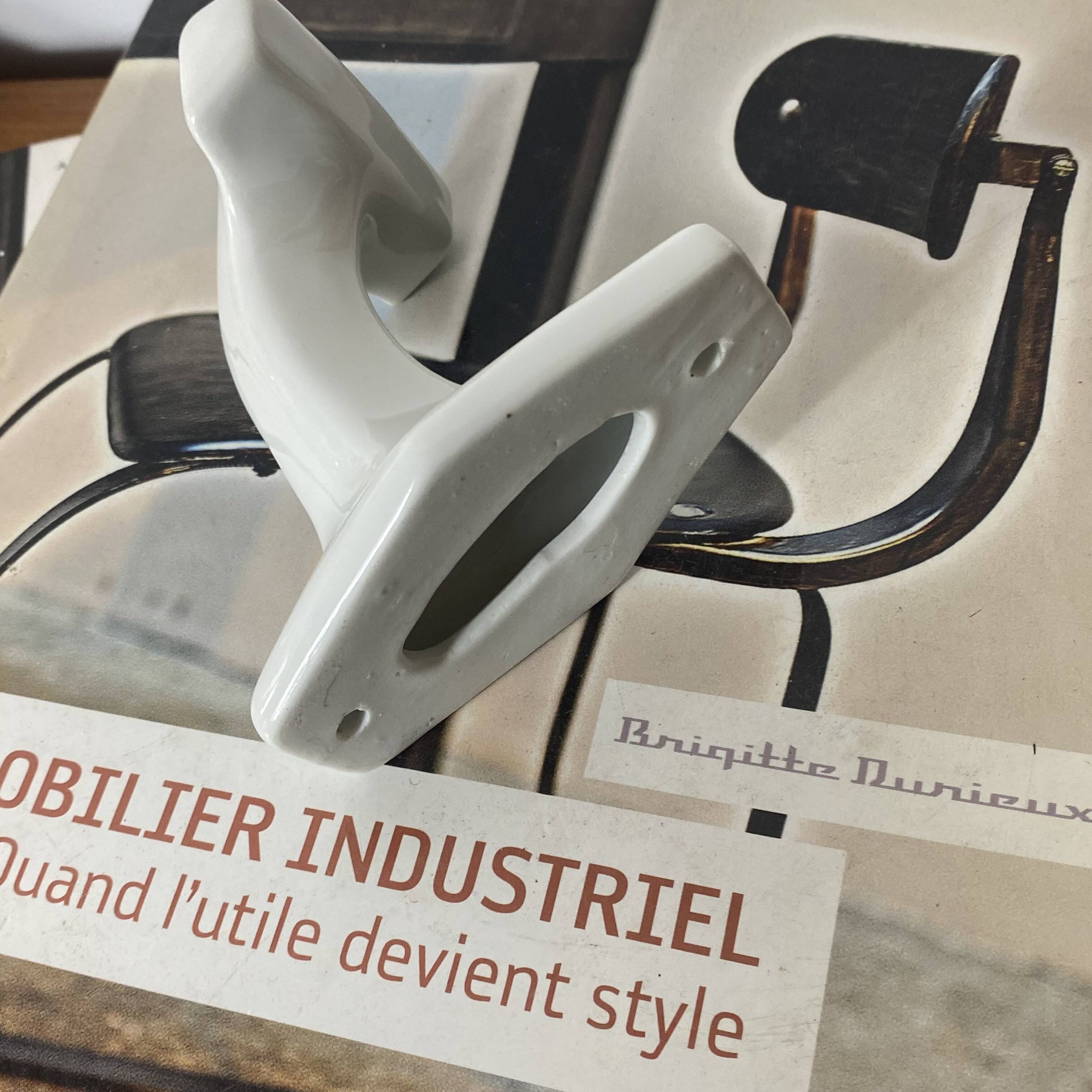 An antique white porcelain coat hook towel holder.