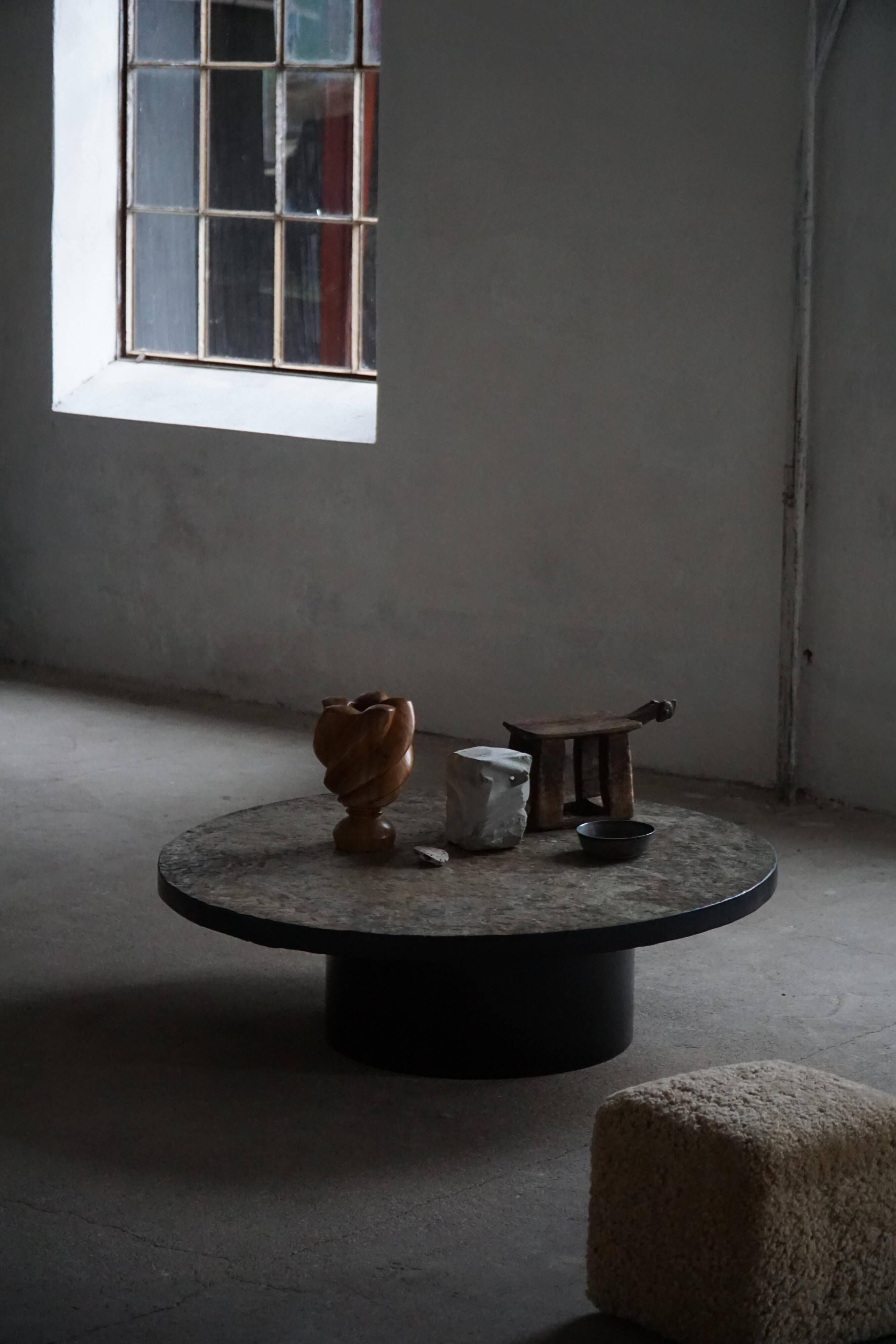 Round brutalist coffee table in stone and steel, mid-century French modernism, 1970s.