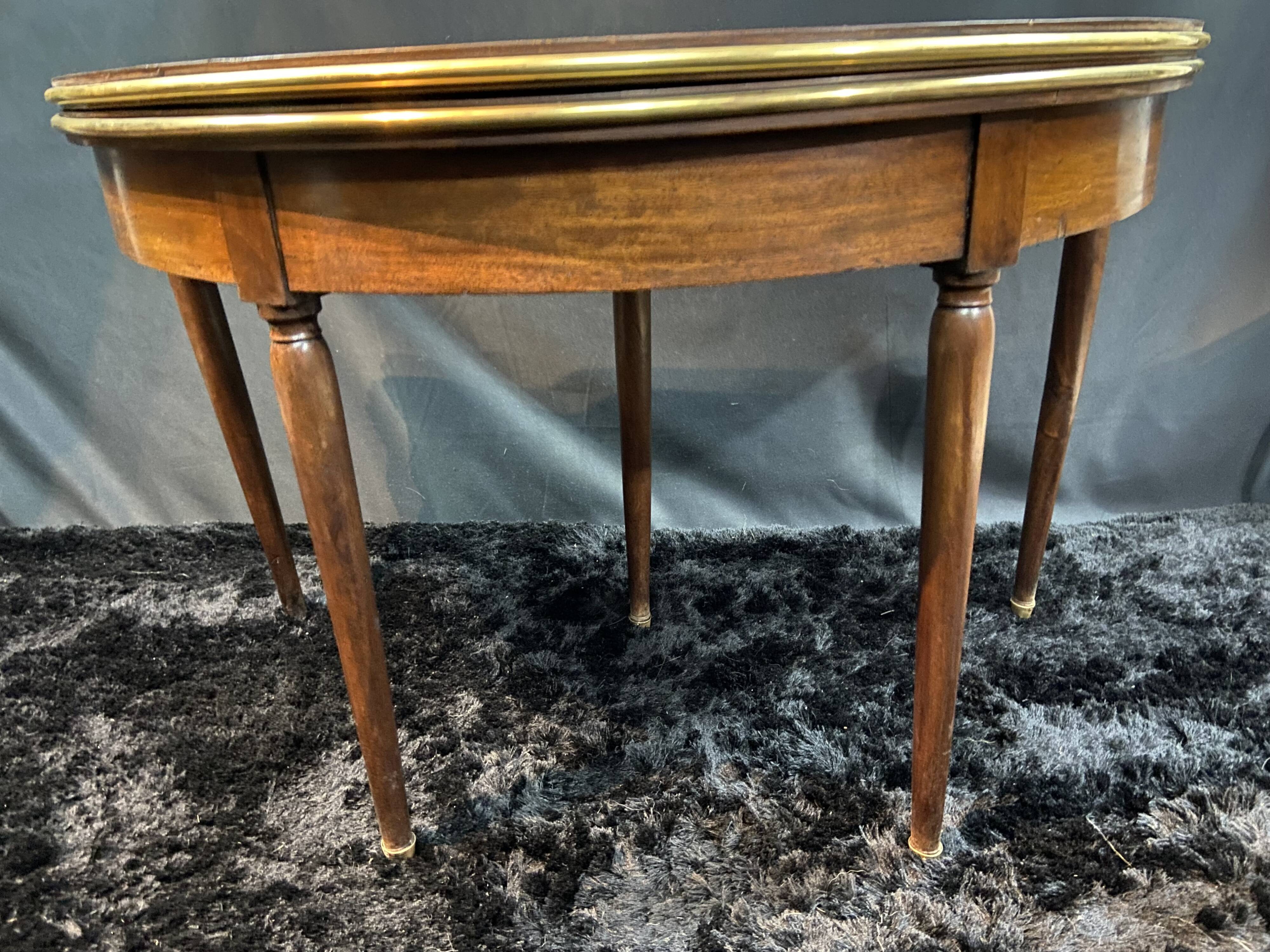 A Louis XVI period mahogany half-moon table forming a console/games table