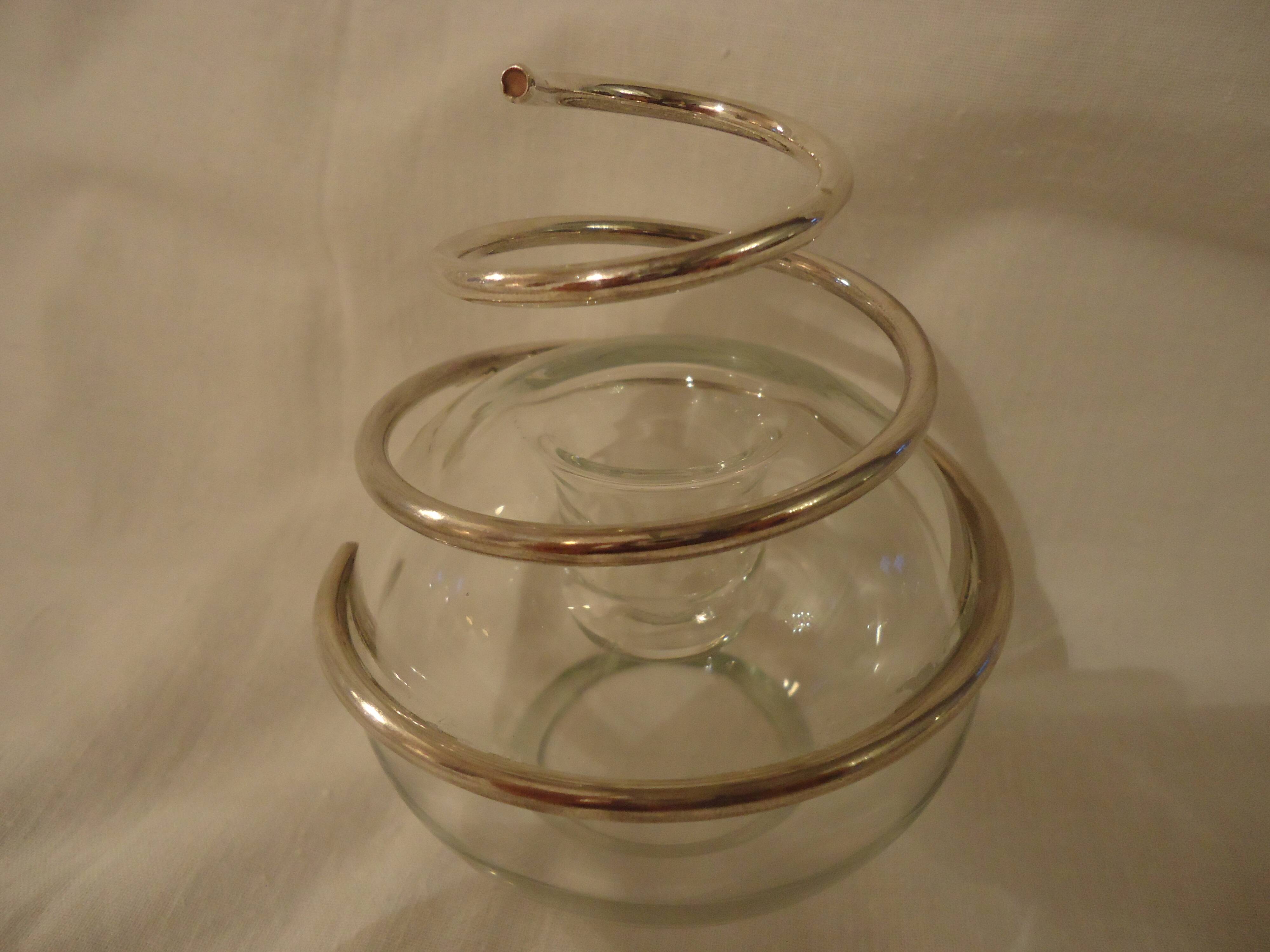 Round glass candle holder with silver-plated metal spiral.