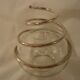 Round glass candle holder with silver-plated metal spiral.
