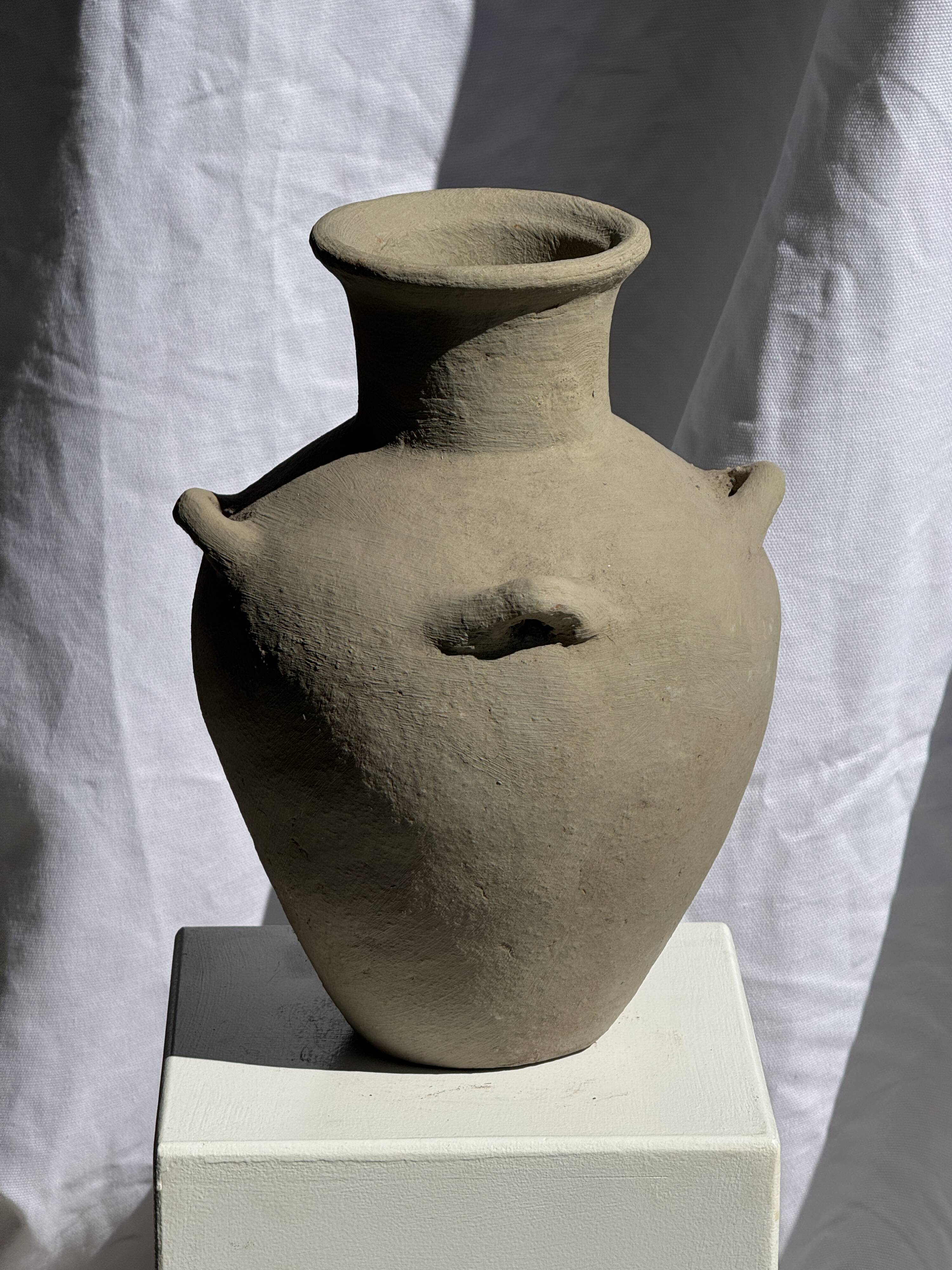 Light beige-grey Indonesian terracotta vase with 4 small handles and a high neck.