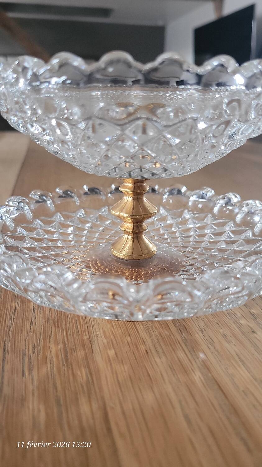 Two-tier display stand in cut glass mounted on a gold metal base.