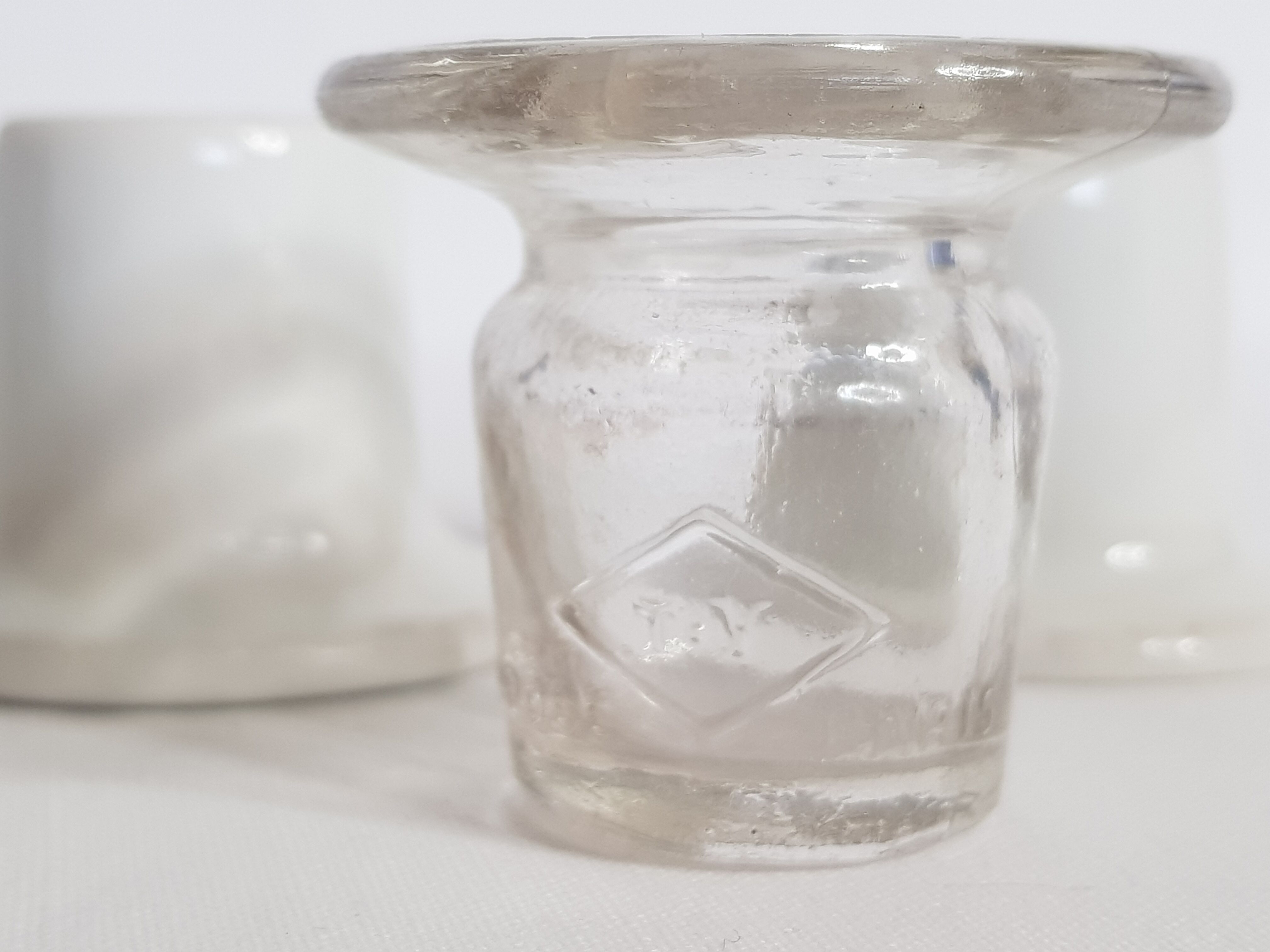 Three white porcelain and glass inkwells for school desk