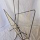Black metal magazine rack with yellow scoubidou wire.