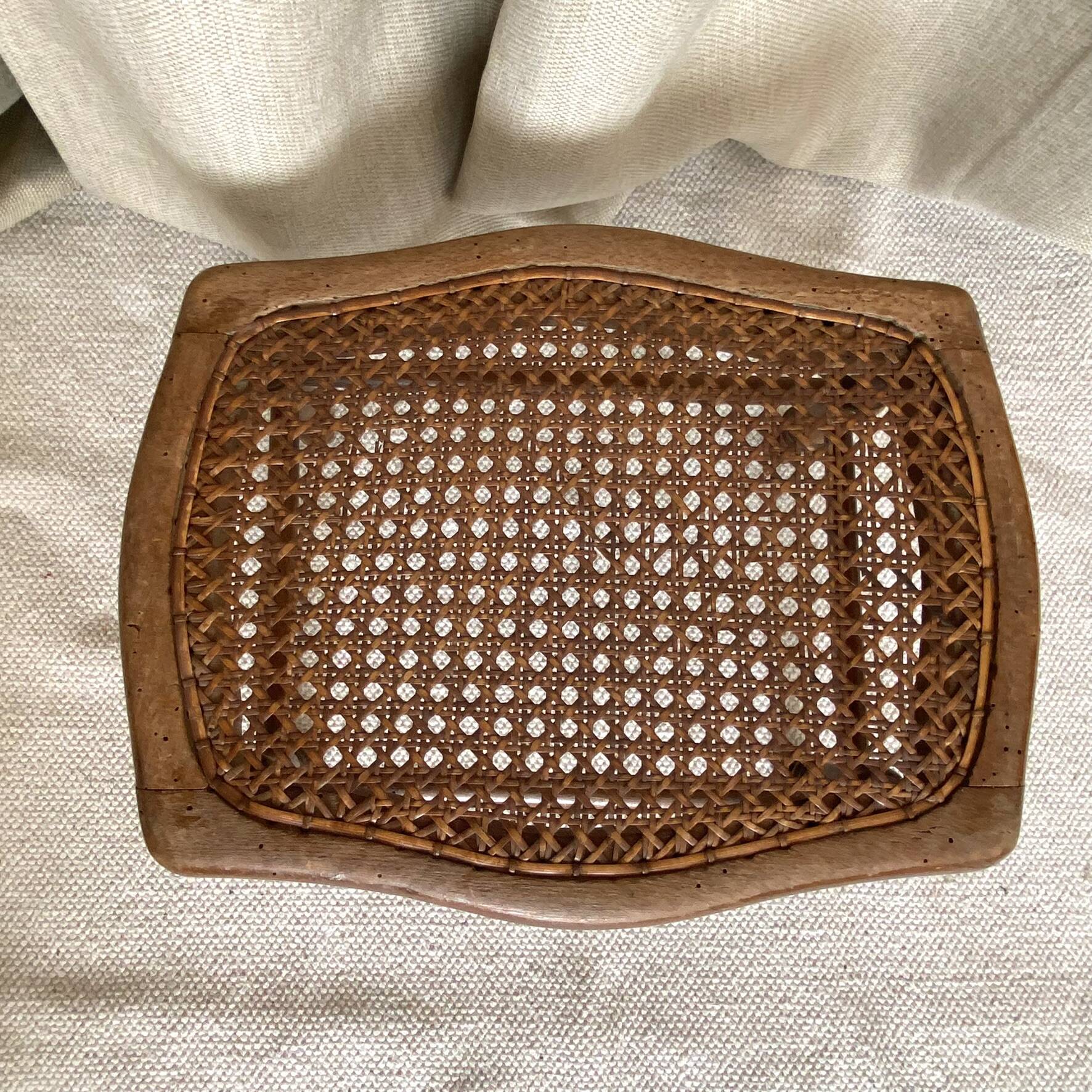 Low wooden stool with caning, footrest.