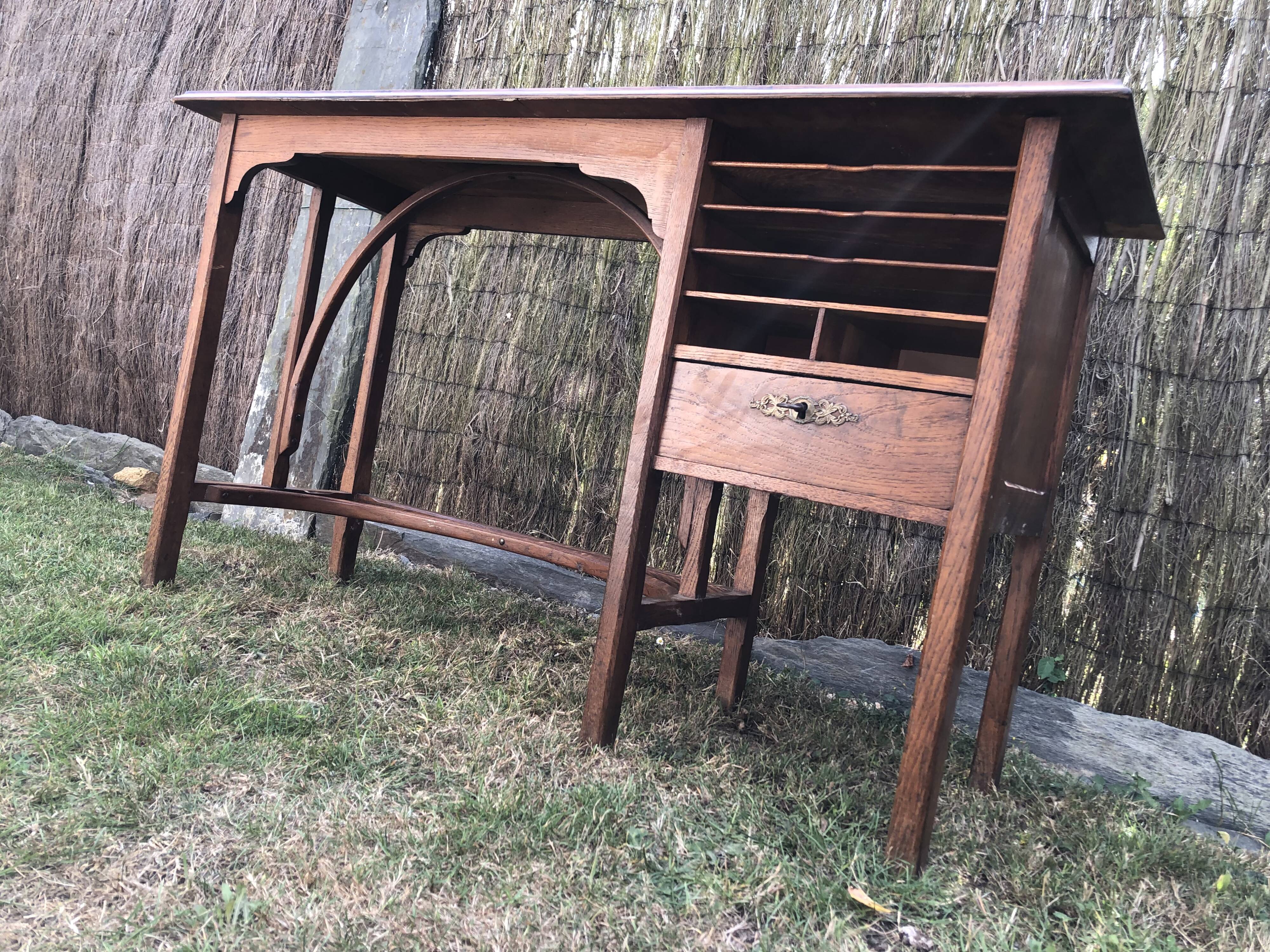 Old oak desk with curved wooden sleepers in the Art Nouveau spirit of the early 20th century.