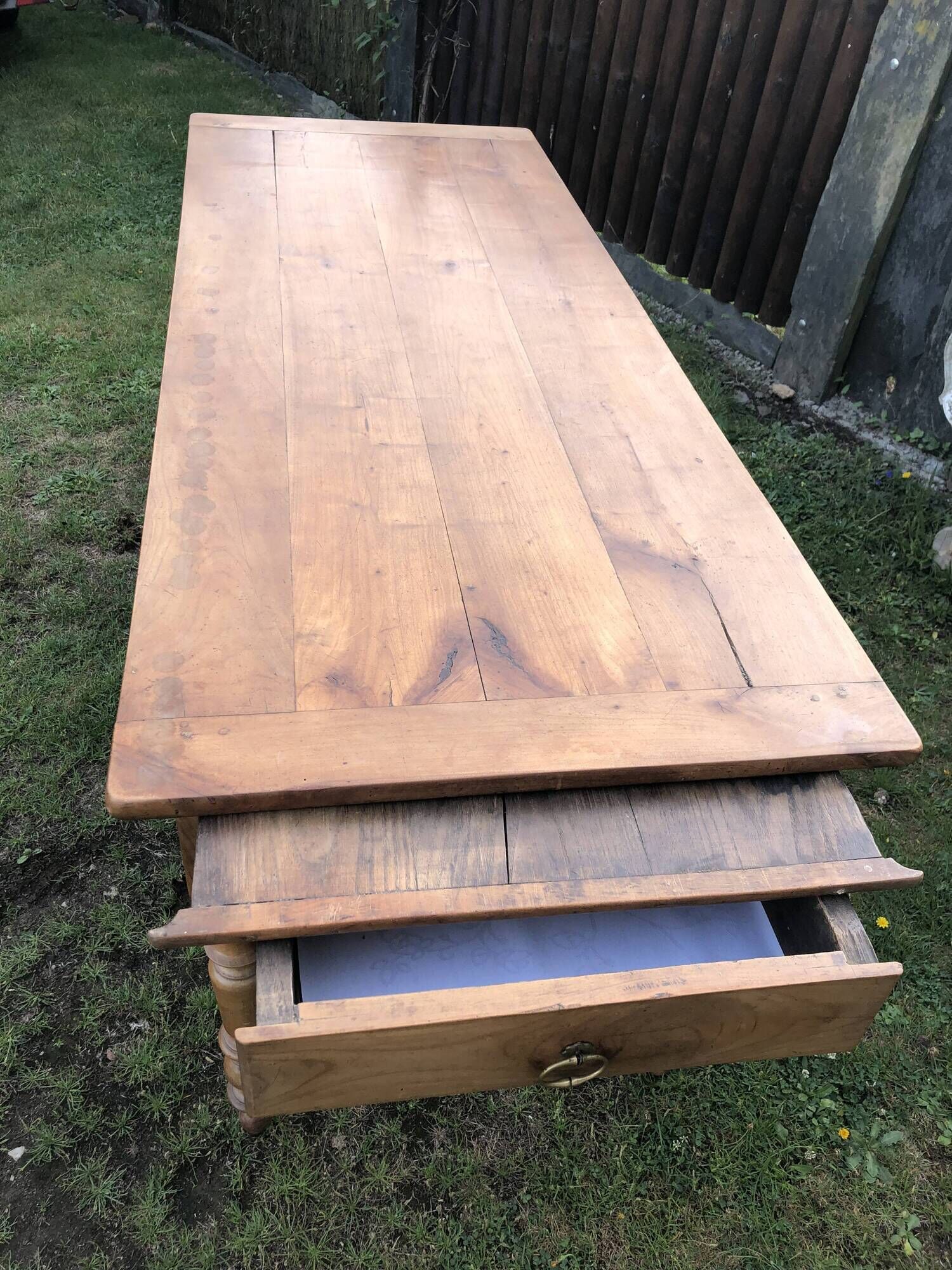 Antique farmhouse table in solid cherry wood with 2 drawers and 1 pull-out at the end with turned legs.