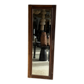 Antique mirror door (left) of a brown oak wardrobe with bevelled glass.