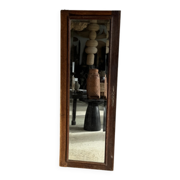 Antique mirror door (left) of a brown oak wardrobe with bevelled glass.