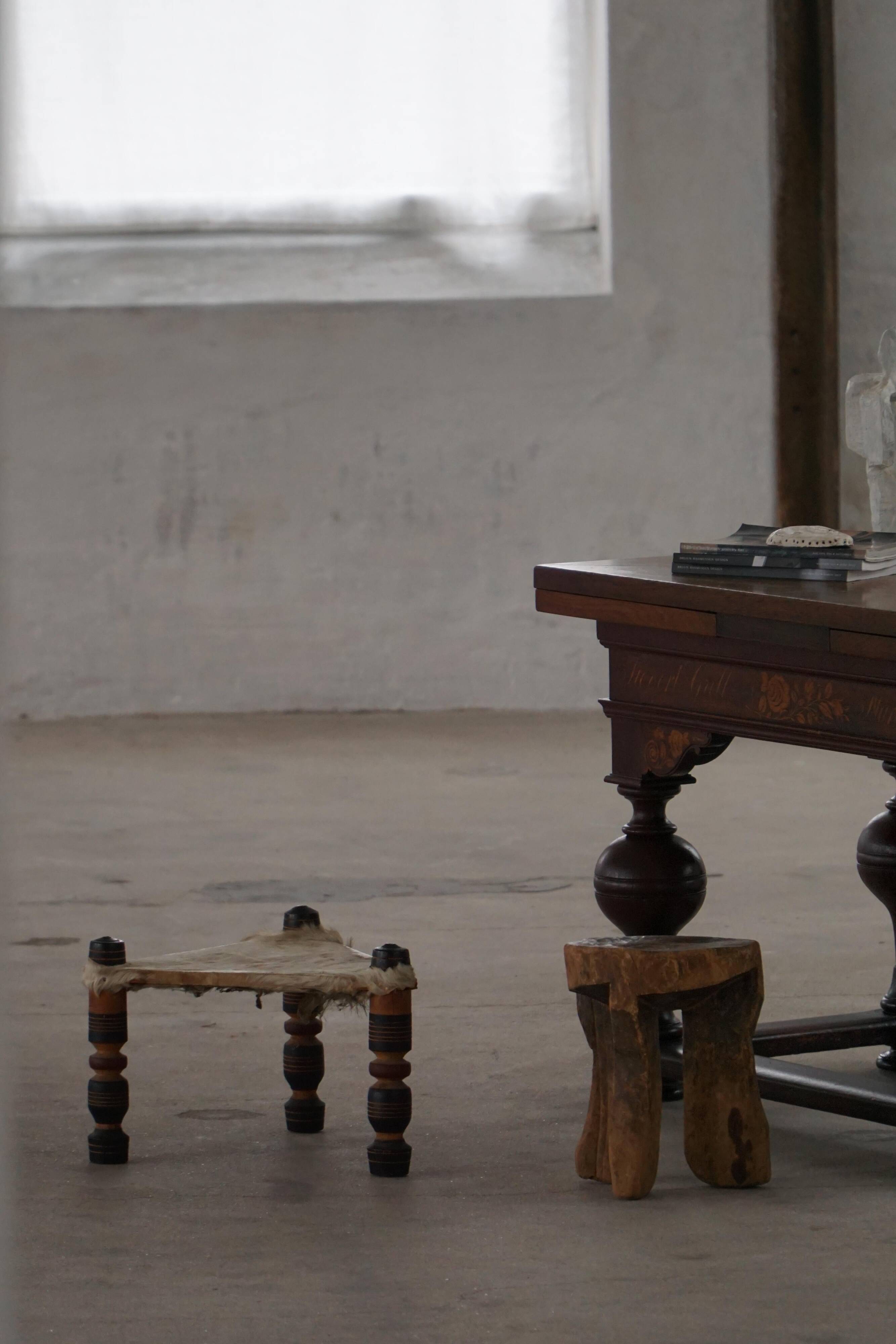 Vintage African artisanal stool, triangular shape with 3 legs, cowhide, 20th century.